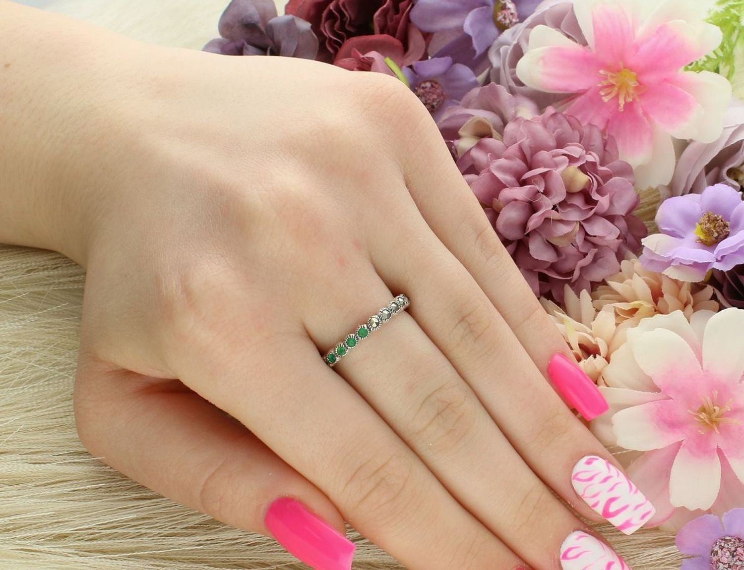 Delikatny pierścionek srebrny próby 925 w formie obrączki, zdobiony markazytami i syntetycznymi szmaragdami. Lekki i wygodny – 2,72 g, szerokość 2 mm.1.jpg