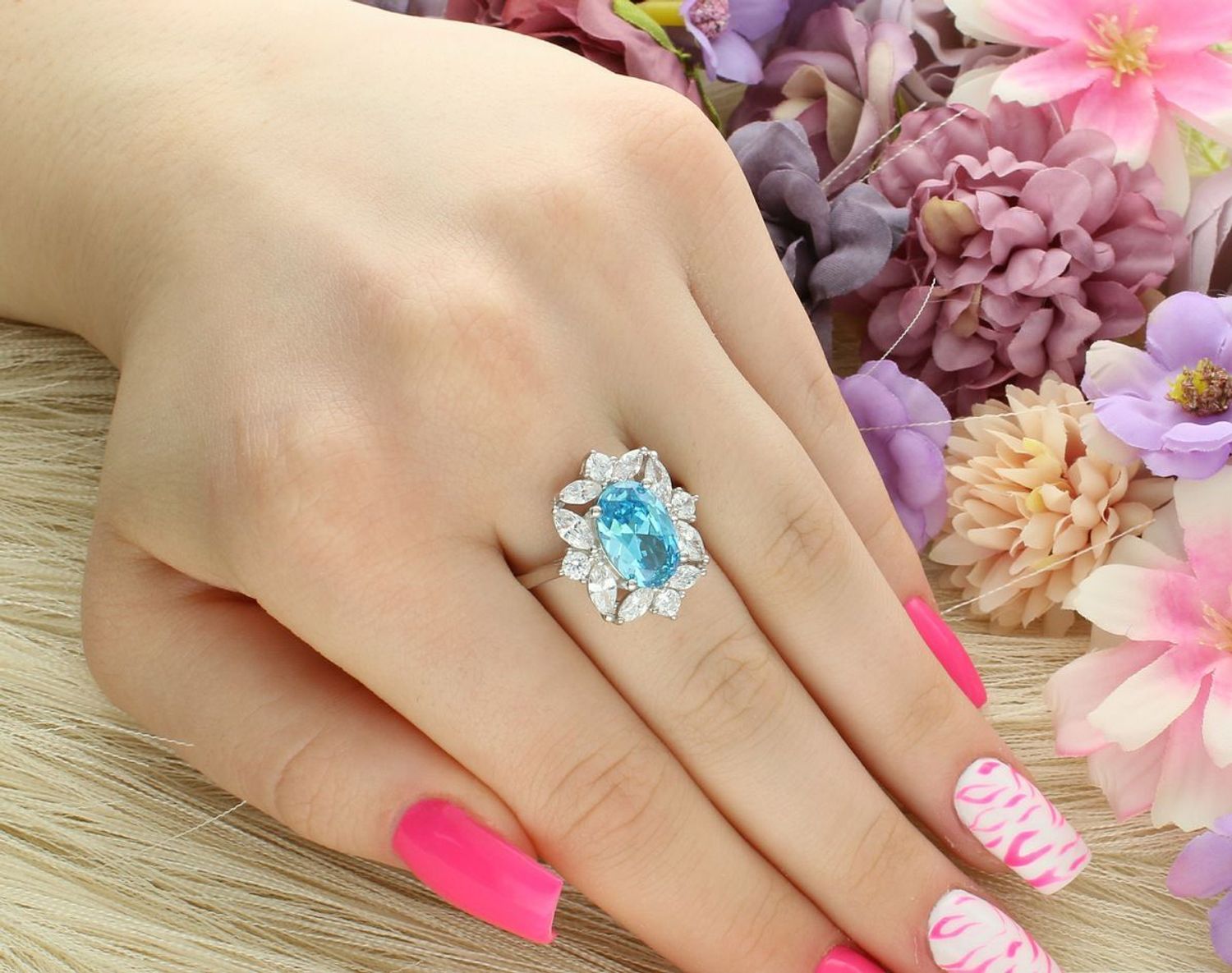 Wyjątkowy srebrny pierścionek z niebieską cyrkonią otoczoną białymi kamieniami. Duży owalny kształt 2,0 × 1,8 cm, waga 6,10 g. Idealny na prezent i eleganckie okazje.1.jpg