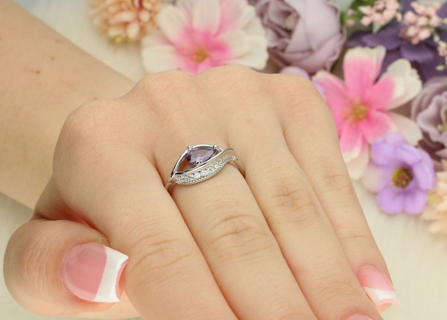 Srebrny pierścionek damski 925 DIA-PRS-13372FIOLET-925 z fioletową cyrkonią w kształcie łezki i mniejszymi białymi kamieniami. Górna część 1 cm, szyna 3 mm, waga 2,50 g.1.jpg
