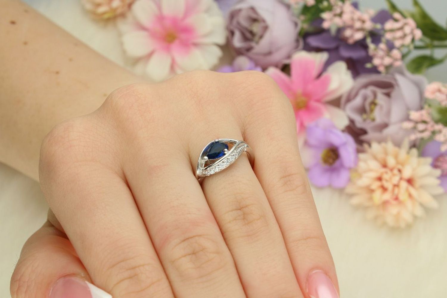 Srebrny pierścionek damski 925 DIA-PRS-13372GRANAT-925 z granatową cyrkonią w kształcie łezki i białymi kamieniami. Ozdobna góra 1 cm, szyna 3 mm, waga 2,50 g. 1.jpg