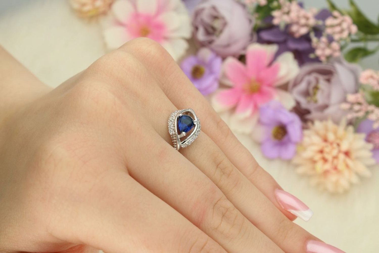 Srebrny pierścionek damski 925 DIA-PRS-13372GRANAT-925 z granatową cyrkonią w kształcie łezki i białymi kamieniami. Ozdobna góra 1 cm, szyna 3 mm, waga 2,50 g. 1.jpg