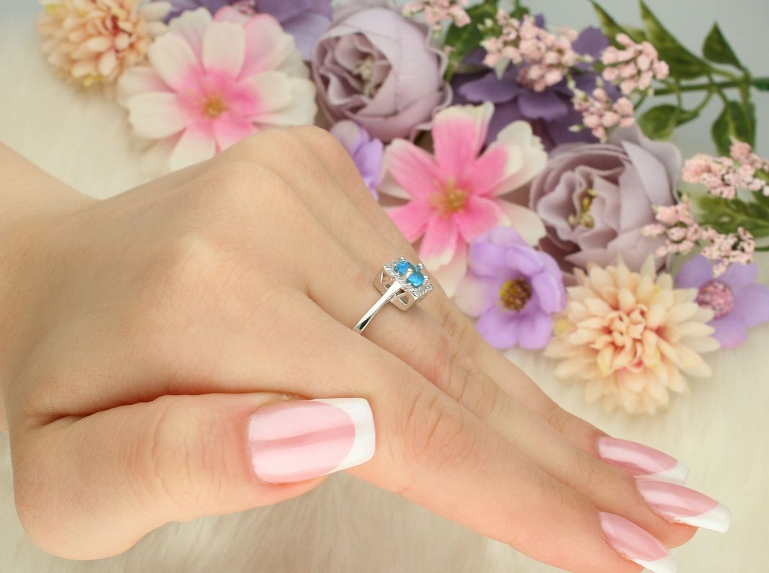 Pierścionek damski srebrny 925 DIA-PRS-13380-925 z błękitną cyrkonią w kwadratowej oprawie i białymi kamieniami. Ozdoba 8 × 8 mm, szyna 3 mm, waga 2,30 g. Elegancki i nowoczesny.1.jpg