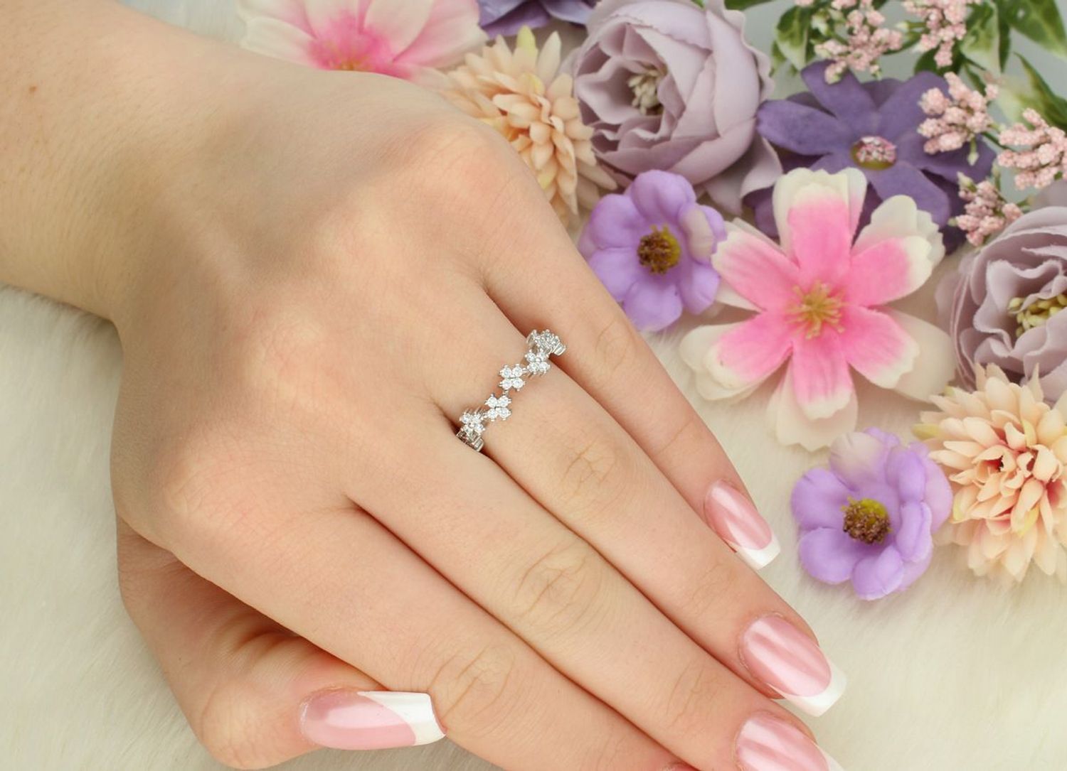 Srebrny pierścionek damski 925 DIA-PRS-13390-925 z siedmioma kwiatkami ozdobionymi cyrkoniami. Szerokość 4 mm, szyna 2 mm, waga 1,90 g. Subtelna i kobieca ozdoba dłoni.1.jpg