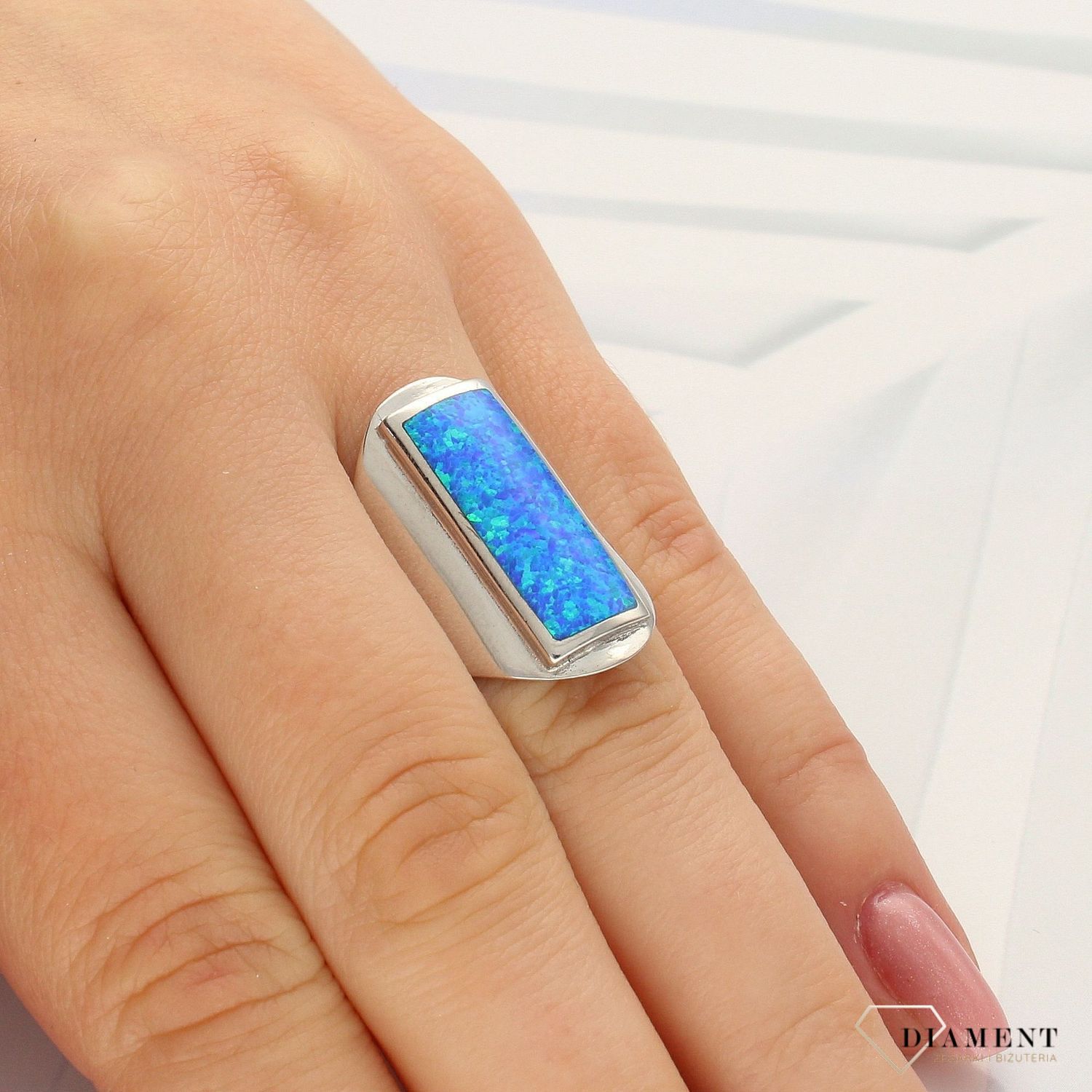 Srebrny pierścionek podłużny sygnet z opalem DIA-PRS-3911-925. Srebrny pierścionek w formie sygnetu w kolorze srebrnym z ozdobną kolorową cyrkonią w kształcie prostokąta (1).jpg