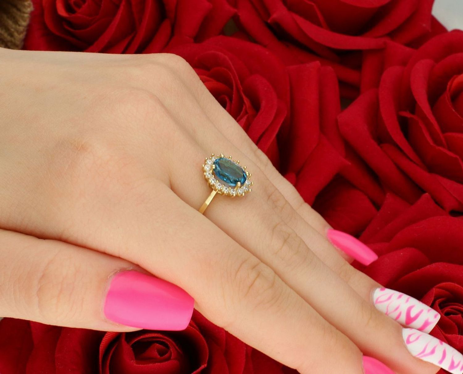 Złoty pierścionek damski DIA-PRS-4289-585 z dużą niebieską cyrkonią i białymi cyrkoniami. Próba 585, waga 2,68 g, rozmiar 15, ozdoba 1,1 x 1,3 cm. Efektowna biżuteria na każdą okazję!1.jpg