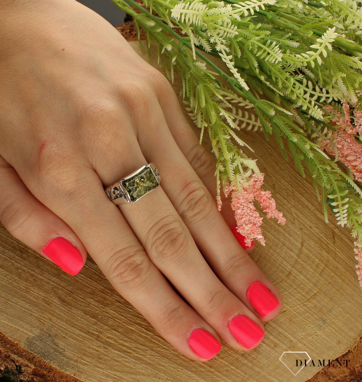 Srebrny pierścionek z zielonym bursztynem DIA-PRS-7143-925. Srebrny pierścionek z bursztynem w kolorze zielonym. Pierścionek srebrny w ponadczasowym kształcie z bursztynem to propozycja od sklepu jubilerskiego Diament (1).jpg