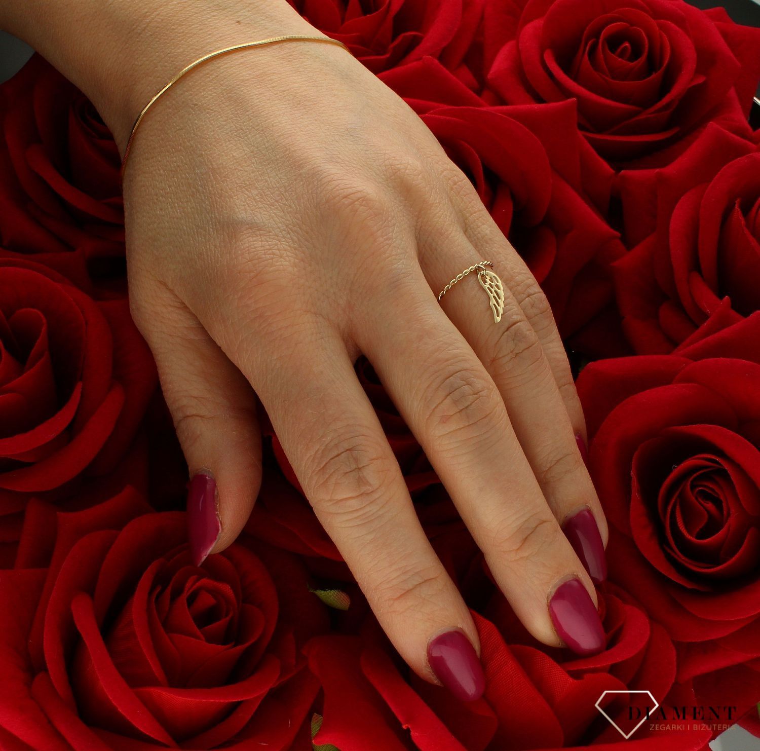 Złoty pierścionek 585 pleciony nowoczesny wzór ze skrzydełkiem rozmiar 11  to złoty damski pierścionek wykonany z wysokiej próby złota 585. Idealna zawieszka w kształcie skrzydełka nadają pierścionkowi nowoczesnego wyglądu ( (4).jpg