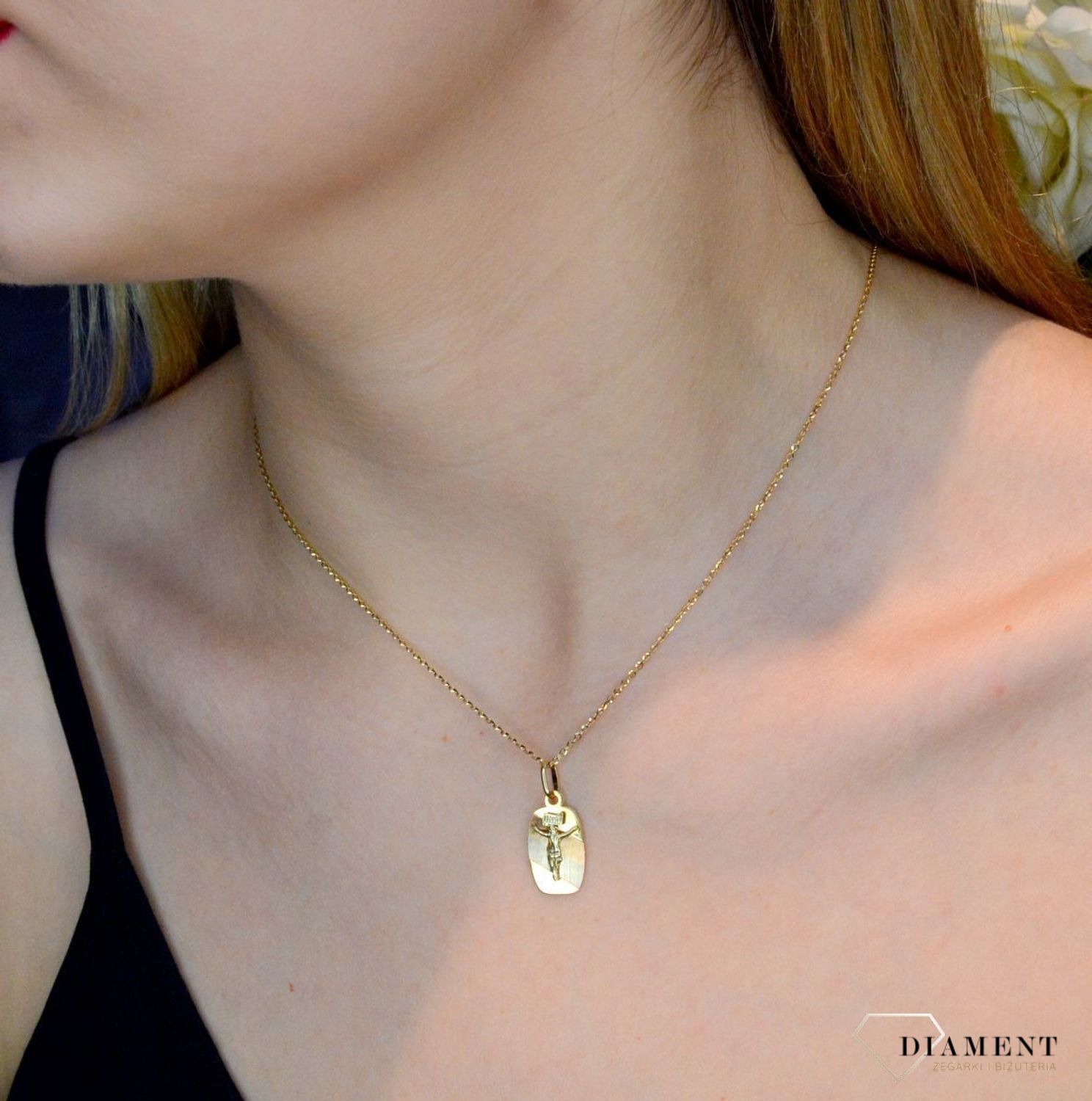 Złoty medalik 585 z wizerunkiem Jezusa na krzyżu DIA-ZAW-0474-585. Medalik będący wspaniałą pamiątką i prezentem z okazji chrztu, komunii czy bierzmowania. Zawieszka wykonana ze złota próby 585 Piękna biżuteria o bogatej symbo.jpg