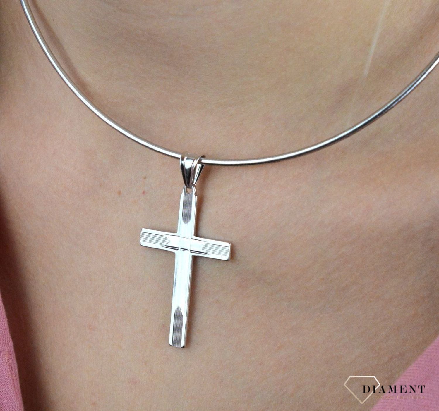 Srebrny krzyżyk wykonany z próby 925 z grawerem w postaci dwóch równoległych i prostopadłych  linii zbiegających się na środku. Piękny i kunsztownie wykonany srebrny krzyżyk z ciekawym zdobieniem w postaci graweru.jpg