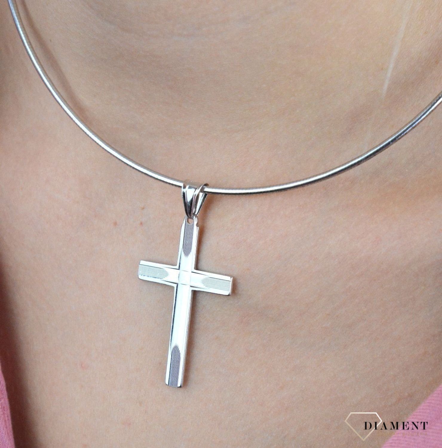 Srebrny krzyżyk wykonany z próby 925 z grawerem w postaci dwóch równoległych i prostopadłych  linii zbiegających się na środku. Piękny i kunsztownie wykonany srebrny krzyżyk z ciekawym zdobieniem w postaci graweru.jpg