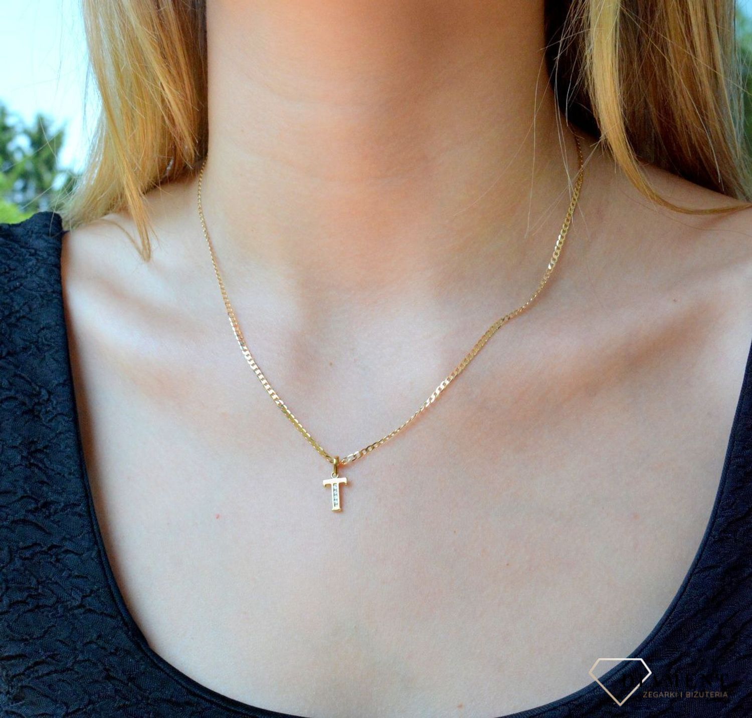 Złota zawieszka 333 literka T ozdobiona cyrkoniami DIA-ZAW-10038-333. Piękny, złoty wisiorek o ciekawym wzorze wykonany z żółtego złota próby 333. Personalizowana zawieszka to doskonały pomysł na prezent dla każdej kobiety. Za.jpg