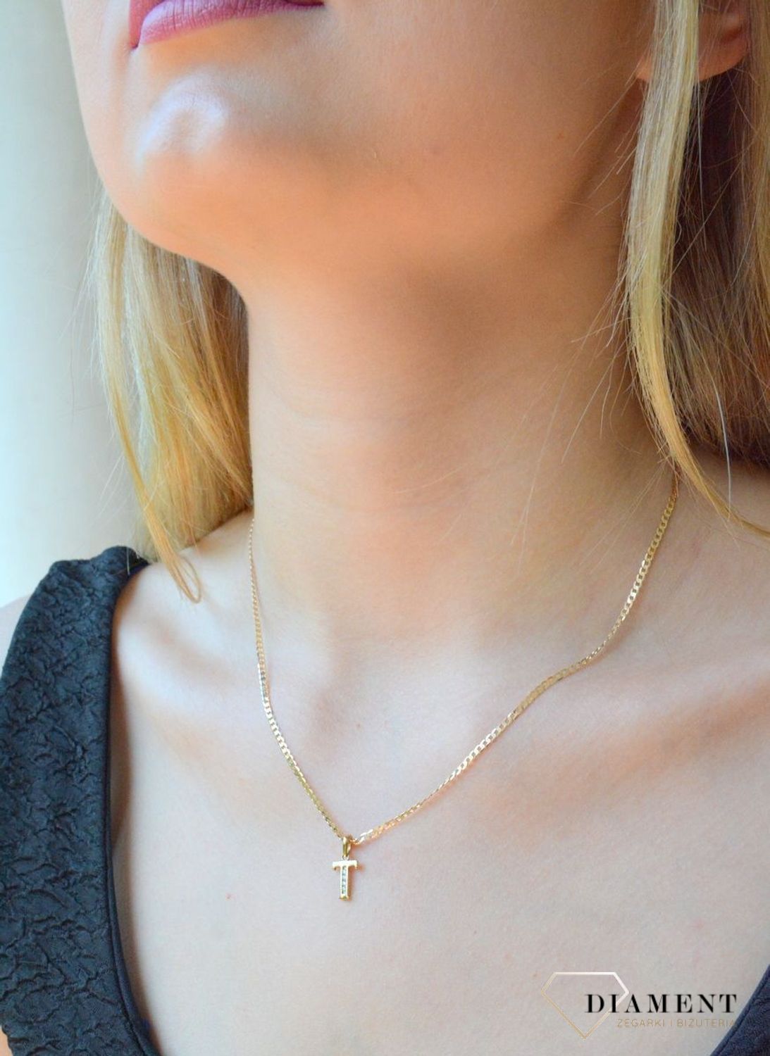 Złota zawieszka 333 literka T ozdobiona cyrkoniami DIA-ZAW-10038-333. Piękny, złoty wisiorek o ciekawym wzorze wykonany z żółtego złota próby 333. Personalizowana zawieszka to doskonały pomysł na prezent dla każdej kobiety. Za.jpg