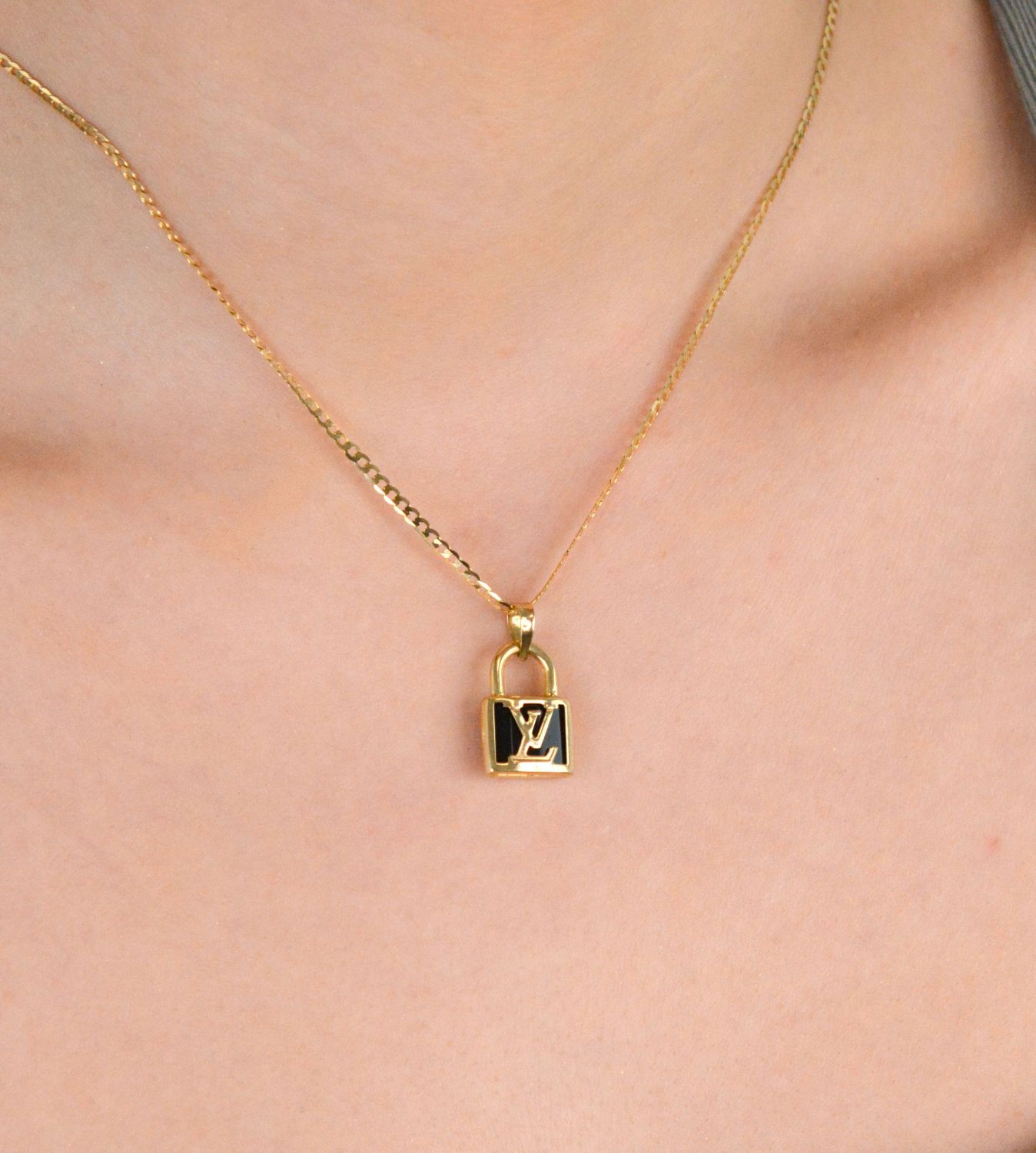 Złota zawieszka kłódka LV - DIA-ZAW-11010-585. Złota zawieszka z modnym logo wykonana z 14-karatowego złota to doskonały pomysł na prezent dla kobiety. Złota zawieszka DIA-ZAW-11010-585 3.jpg