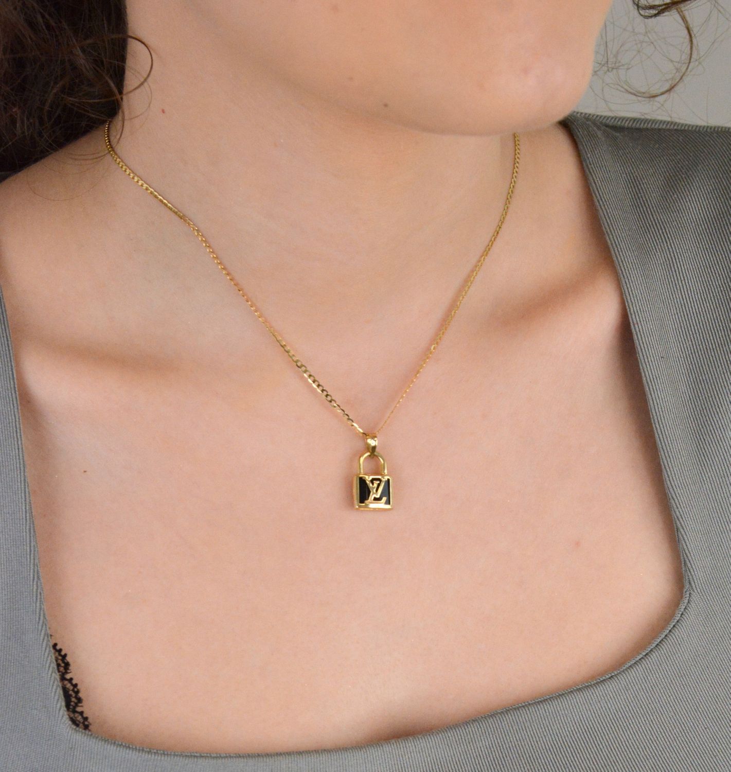 Złota zawieszka kłódka LV - DIA-ZAW-11010-585. Złota zawieszka z modnym logo wykonana z 14-karatowego złota to doskonały pomysł na prezent dla kobiety. Złota zawieszka DIA-ZAW-11010-585 3.jpg