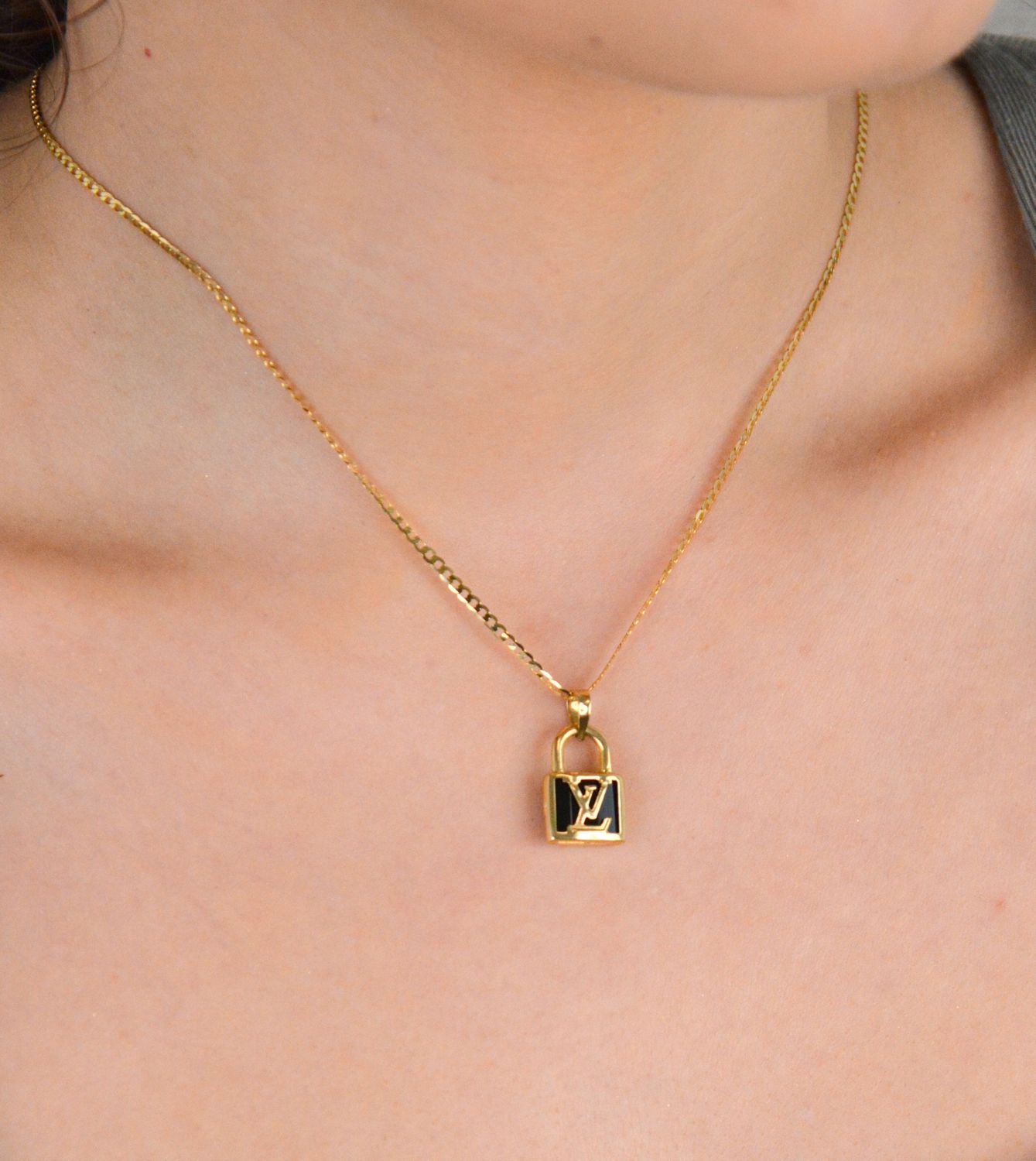 Złota zawieszka kłódka LV - DIA-ZAW-11010-585. Złota zawieszka z modnym logo wykonana z 14-karatowego złota to doskonały pomysł na prezent dla kobiety. Złota zawieszka DIA-ZAW-11010-585 3.jpg