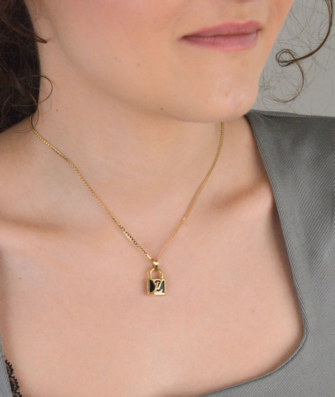 Złota zawieszka kłódka LV - DIA-ZAW-11010-585. Złota zawieszka z modnym logo wykonana z 14-karatowego złota to doskonały pomysł na prezent dla kobiety. Złota zawieszka DIA-ZAW-11010-585 3.jpg