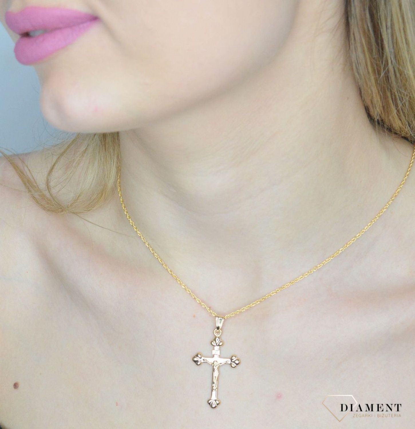 Krzyżyk z wizerunkiem Pana Jezusa DIA-ZAW-11256-375 z ozdobnym grawerem wykonany ze złota próby 375. Zawieszka wykonana z niezwykłą starannością i dbałością o szczegóły.webp