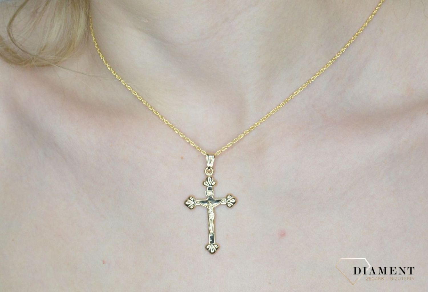 Krzyżyk z wizerunkiem Pana Jezusa DIA-ZAW-11256-375 z ozdobnym grawerem wykonany ze złota próby 375. Zawieszka wykonana z niezwykłą starannością i dbałością o szczegóły.webp