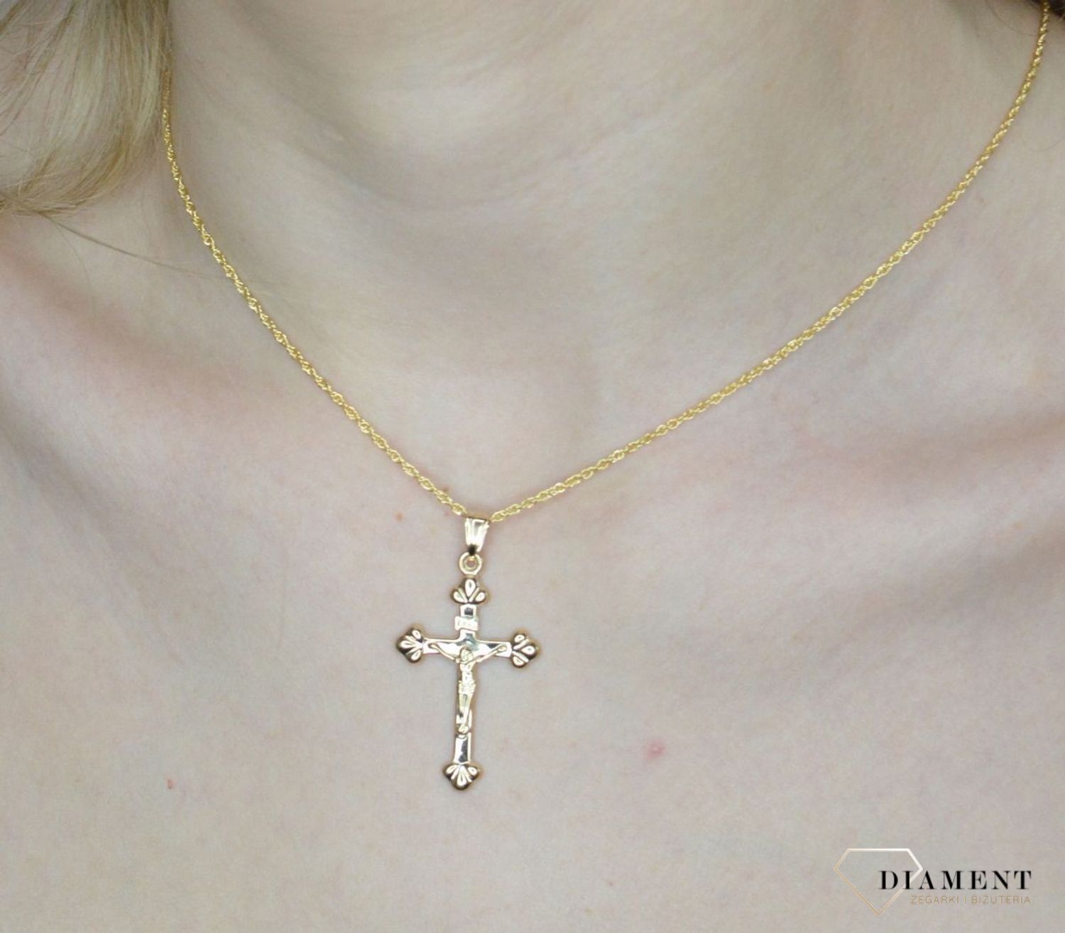 Krzyżyk z wizerunkiem Pana Jezusa DIA-ZAW-11256-375 z ozdobnym grawerem wykonany ze złota próby 375. Zawieszka wykonana z niezwykłą starannością i dbałością o szczegóły.webp