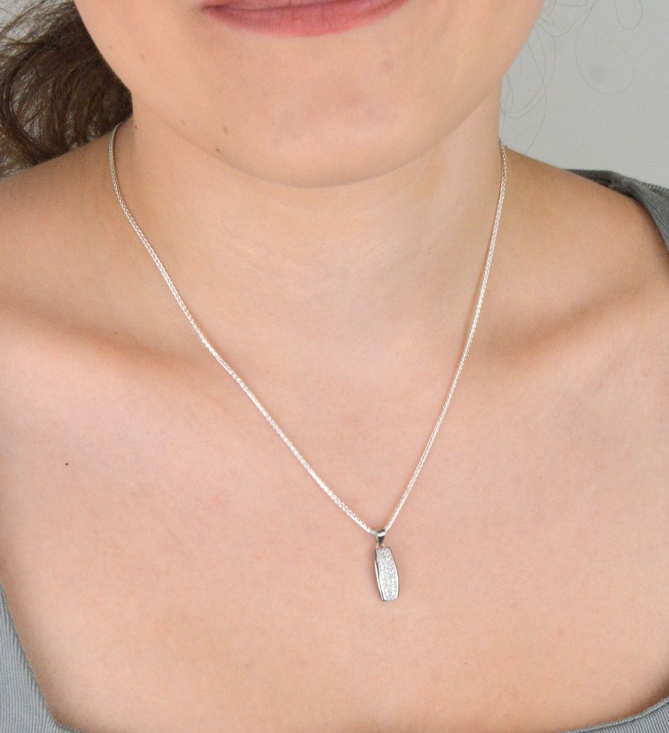 Zawieszka srebrna próby 925 DIA-ZAW-11828-925, podłużna, zdobiona białymi cyrkoniami. Długość z oczkiem 2,0 cm, szerokość 7 mm, waga 1,10 g. Elegancka biżuteria na każdą okazję.1.jpg