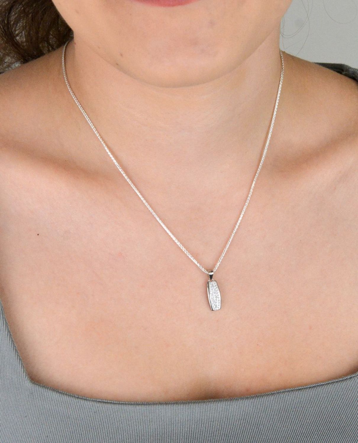 Zawieszka srebrna próby 925 DIA-ZAW-11828-925, podłużna, zdobiona białymi cyrkoniami. Długość z oczkiem 2,0 cm, szerokość 7 mm, waga 1,10 g. Elegancka biżuteria na każdą okazję.1.jpg