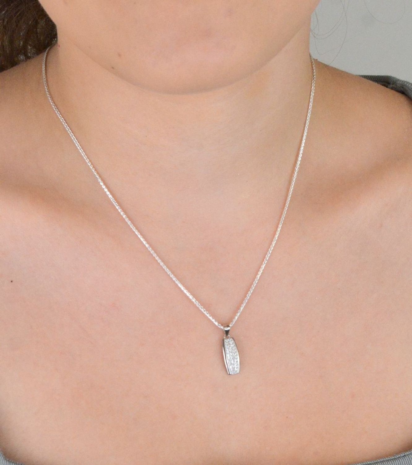 Zawieszka srebrna próby 925 DIA-ZAW-11828-925, podłużna, zdobiona białymi cyrkoniami. Długość z oczkiem 2,0 cm, szerokość 7 mm, waga 1,10 g. Elegancka biżuteria na każdą okazję.1.jpg