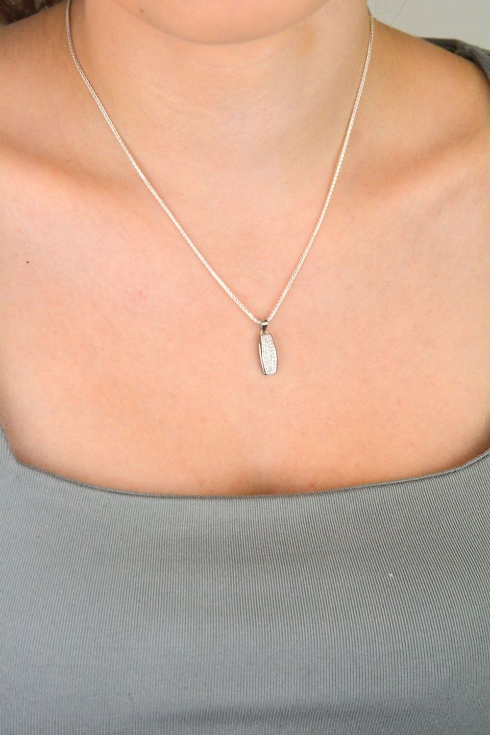 Zawieszka srebrna próby 925 DIA-ZAW-11828-925, podłużna, zdobiona białymi cyrkoniami. Długość z oczkiem 2,0 cm, szerokość 7 mm, waga 1,10 g. Elegancka biżuteria na każdą okazję.1.jpg