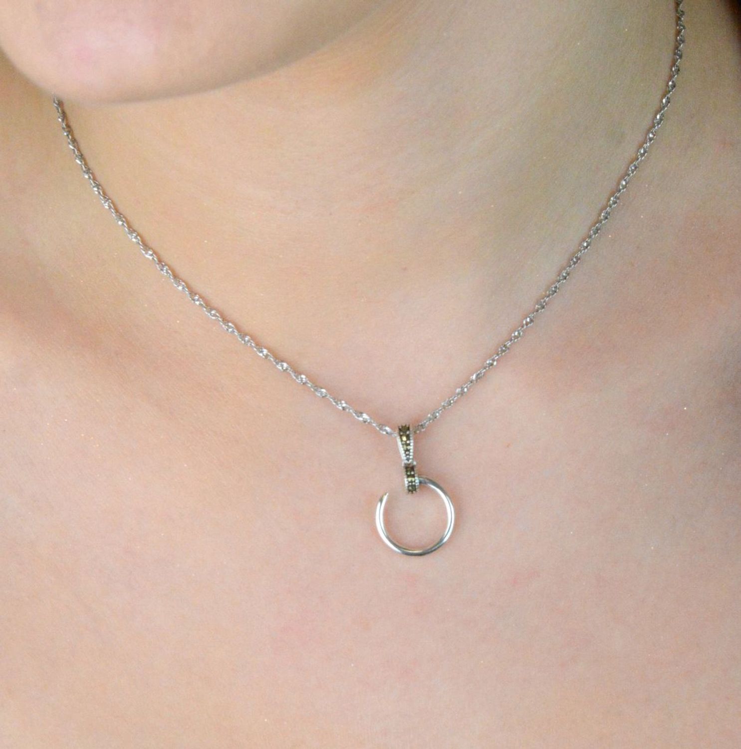 Delikatna zawieszka srebrna próby 925 w kształcie przerywanego kółeczka, zdobiona markazytami. Długość 2,3 cm, szerokość 1,4 cm. Model DIA-ZAW-13087-925 – subtelna elegancja.1.jpg