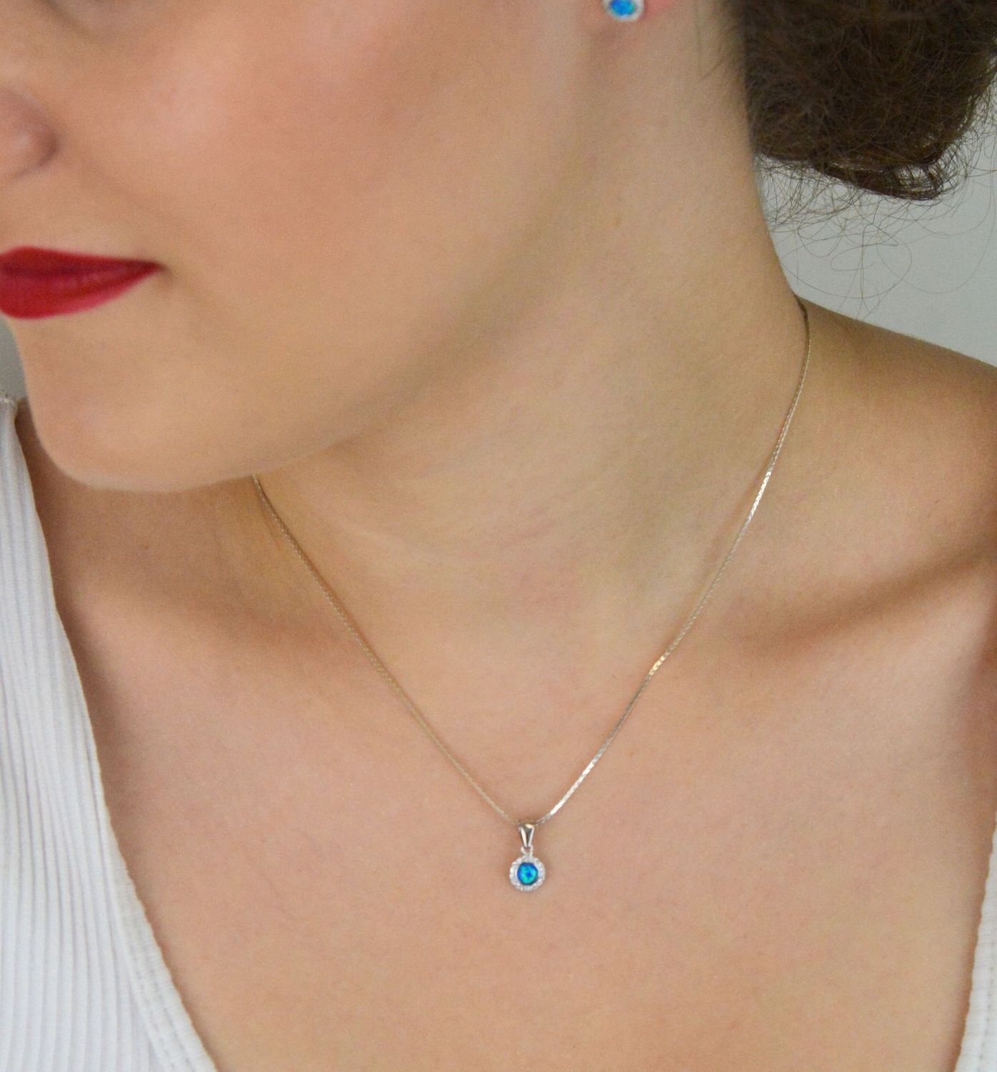 Zawieszka srebrna damska z niebieskim syntetycznym opalem i cyrkoniami. Próba 925, wymiary 1,3 cm x 7 mm, lekka – 0,50 g. Idealna jako elegancki dodatek lub prezent.1.jpg