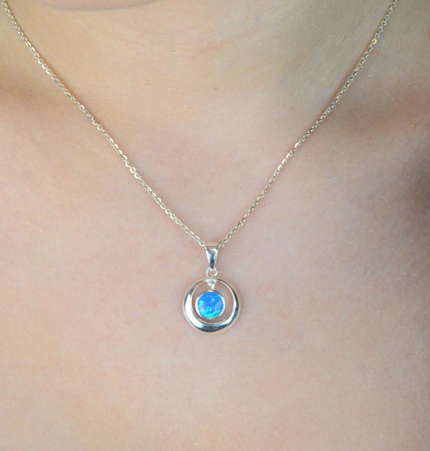 Zawieszka damska srebrna DIA-ZAW-13176-925 – okrągła z niebieskim syntetycznym opalem, próba 925, długość 2,5 cm, szerokość 1,5 cm, waga 2,10 g.1.jpg