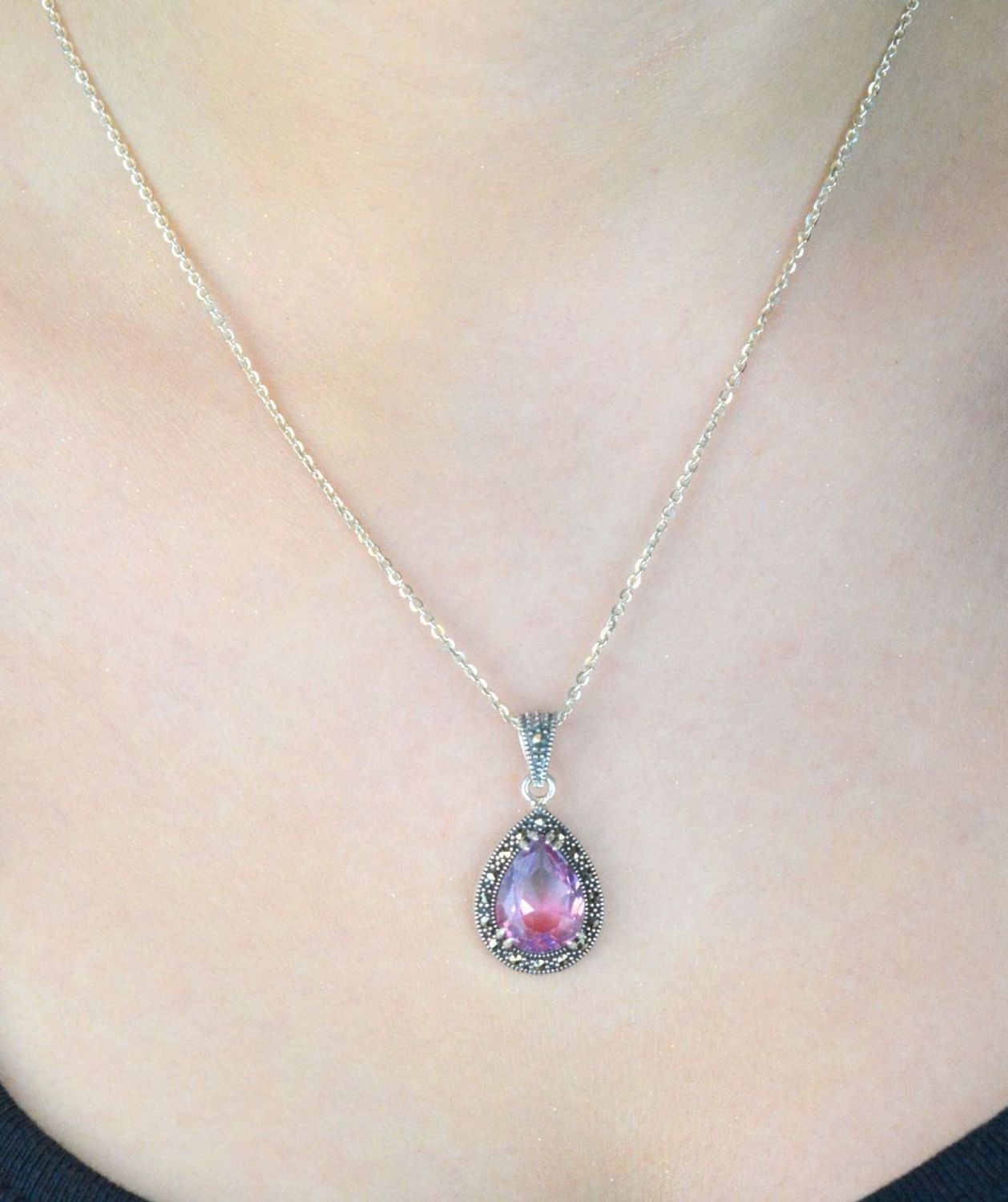 Zawieszka srebrna próby 925 z cyrkonią różowo-fioletową i markazytami. Kształt łezki, wymiary 3,0 x 1,5 cm, waga 3,20 g. Model DIA-ZAW-13185-925 – klasyka z nutą koloru.1.jpg