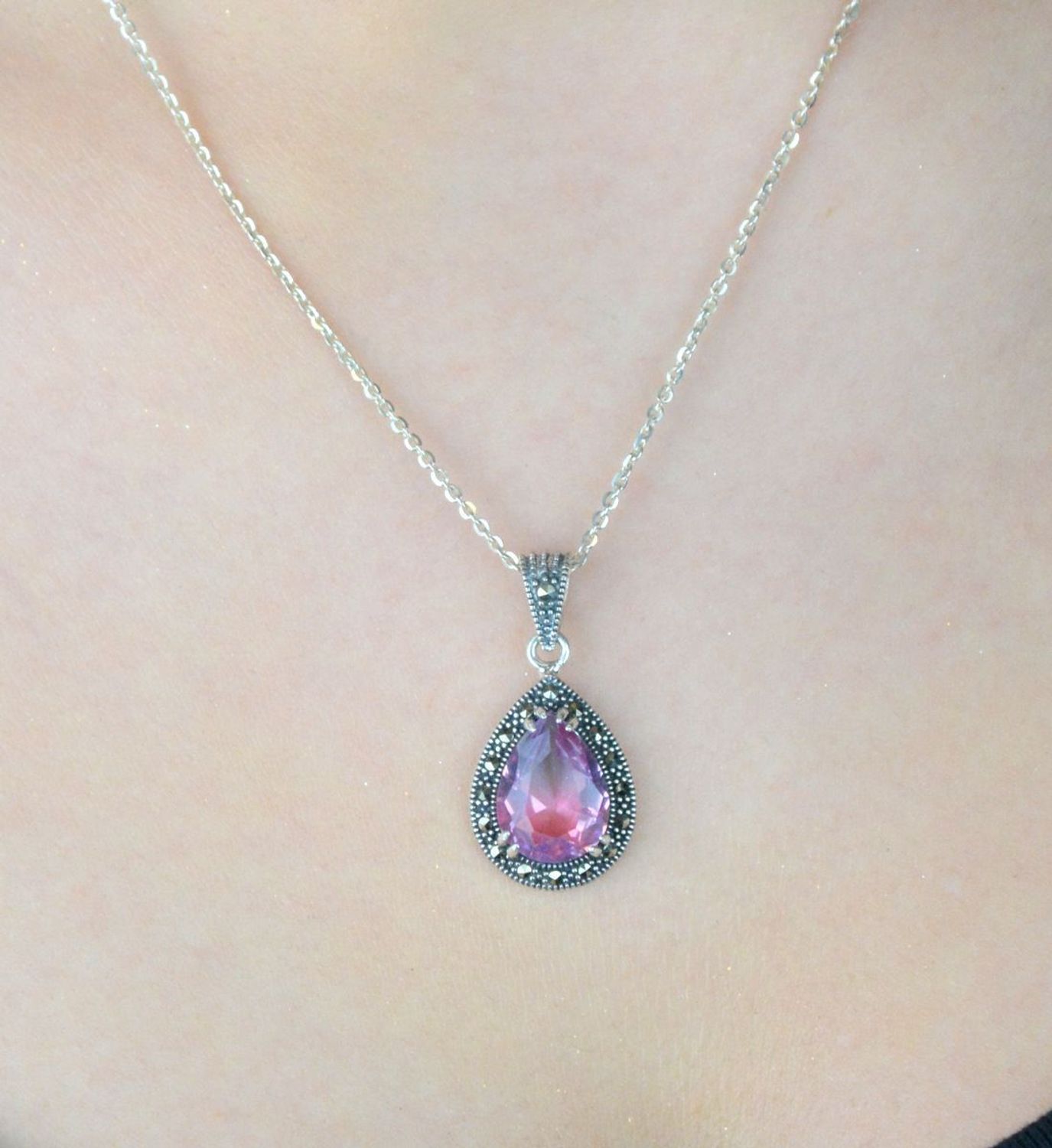 Zawieszka srebrna próby 925 z cyrkonią różowo-fioletową i markazytami. Kształt łezki, wymiary 3,0 x 1,5 cm, waga 3,20 g. Model DIA-ZAW-13185-925 – klasyka z nutą koloru.1.jpg