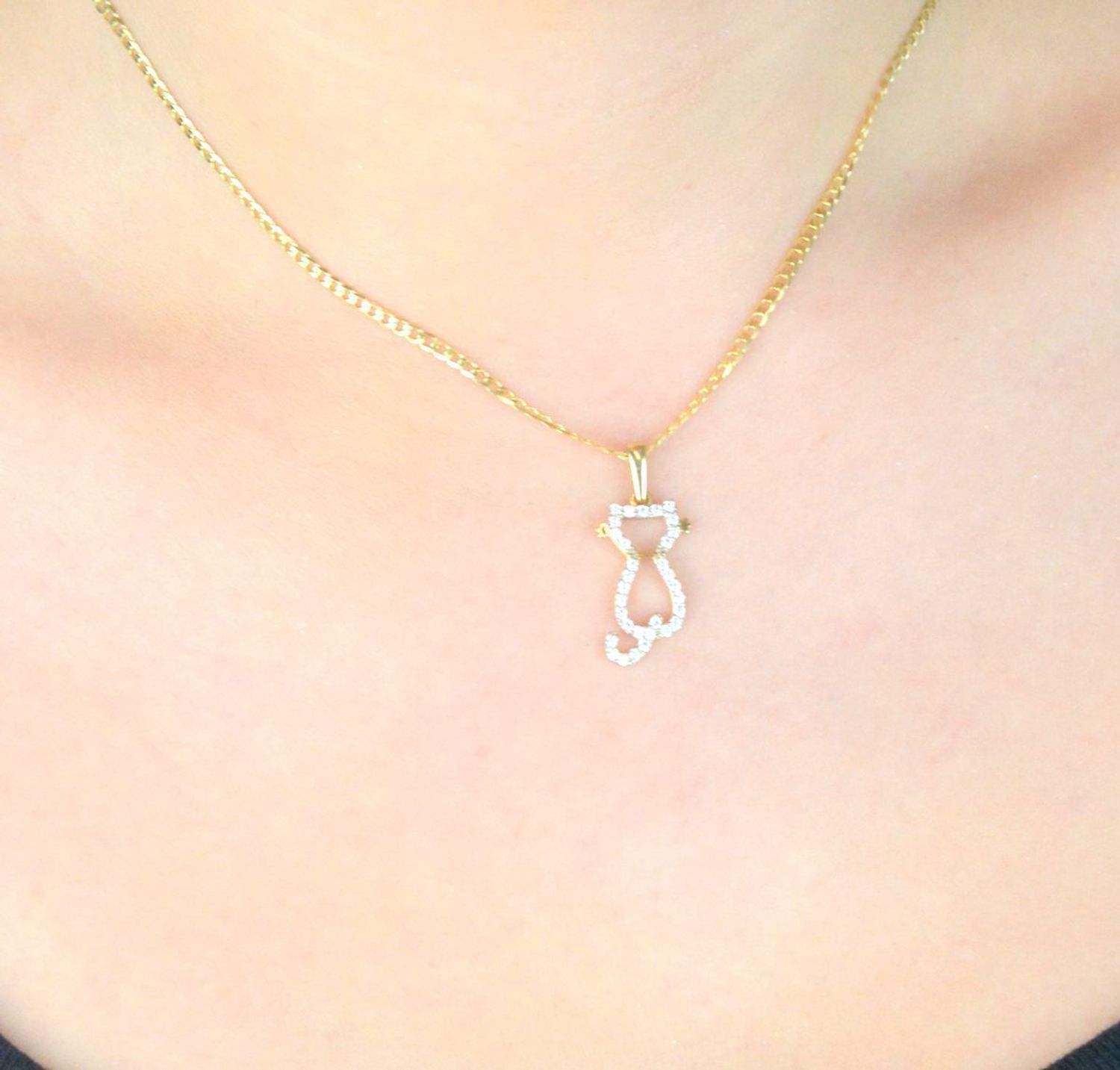 Złota zawieszka DIA-ZAW-13303-585 w kształcie kota z białymi cyrkoniami. Próba 585, waga 1,03 g, wymiary 2,6 cm x 8 mm. Uroczy i elegancki dodatek – idealny na prezent.1.jpg