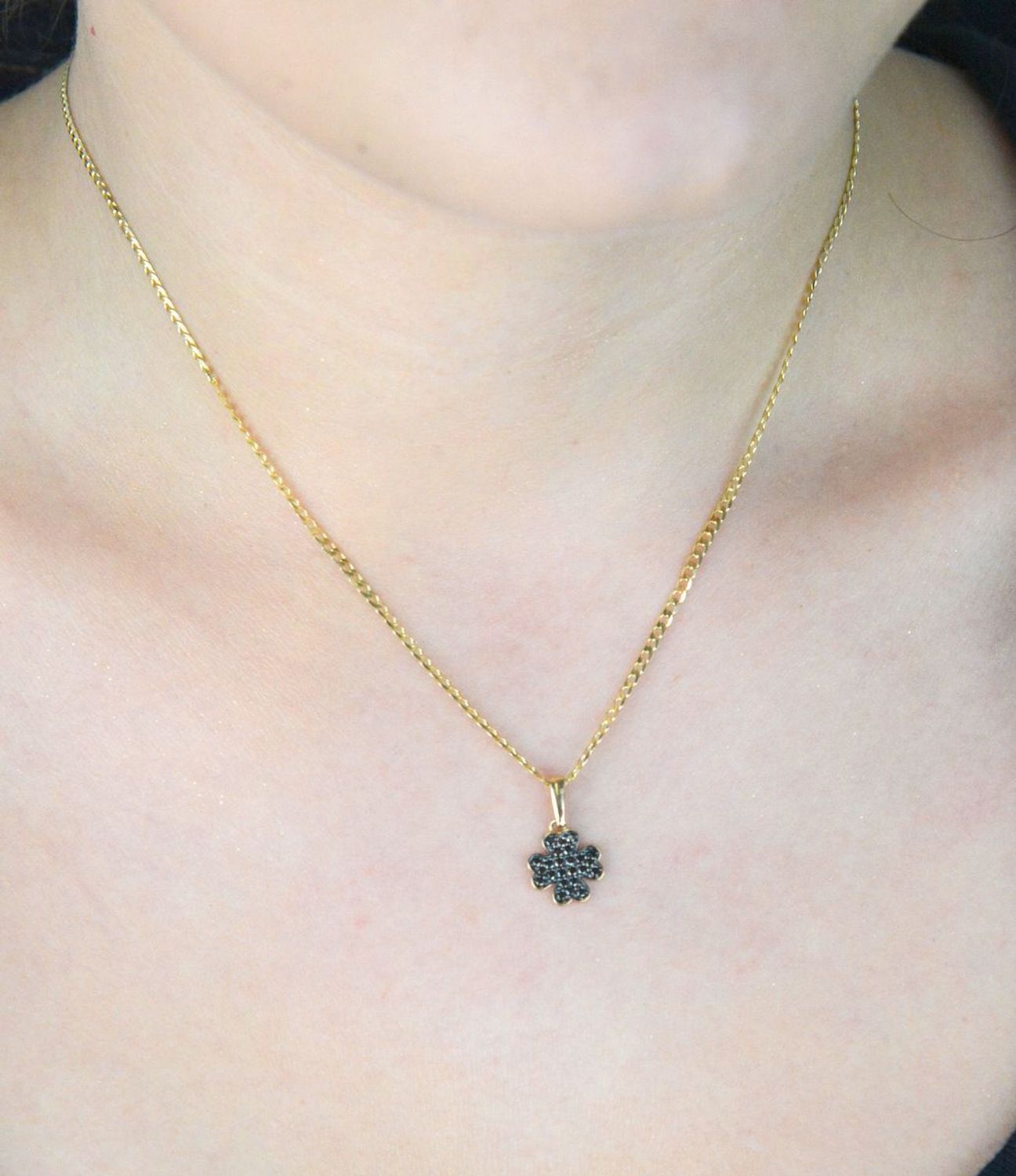 Złota zawieszka DIA-ZAW-13309-585 w kształcie koniczynki, zdobiona czarnymi cyrkoniami. Próba 585, waga 0,75 g, wymiary 1,7 × 1,0 cm. Stylowy symbol szczęścia – idealny na prezent!1.jpg