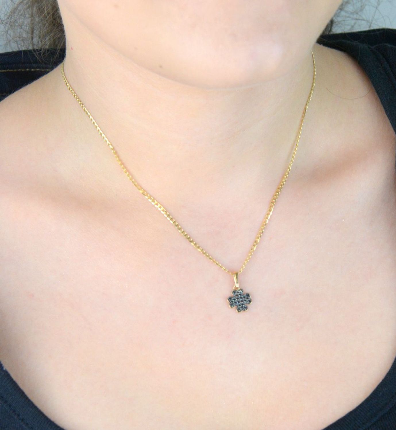 Złota zawieszka DIA-ZAW-13309-585 w kształcie koniczynki, zdobiona czarnymi cyrkoniami. Próba 585, waga 0,75 g, wymiary 1,7 × 1,0 cm. Stylowy symbol szczęścia – idealny na prezent!1.jpg