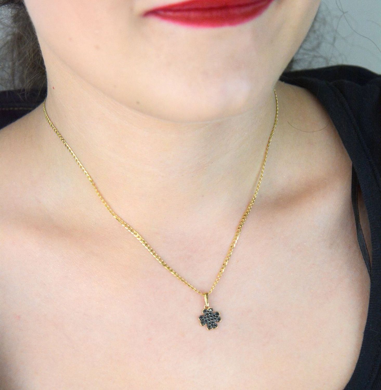 Złota zawieszka DIA-ZAW-13309-585 w kształcie koniczynki, zdobiona czarnymi cyrkoniami. Próba 585, waga 0,75 g, wymiary 1,7 × 1,0 cm. Stylowy symbol szczęścia – idealny na prezent!1.jpg