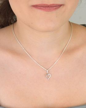 Subtelna srebrna zawieszka DIA-ZAW-13334-925 w kształcie małego, otwartego serca, zdobiona cyrkoniami. Próba 925, waga 0,70 g, długość 2,0 cm x 1,0 cm. Idealna na prezent z miłością (2).JPG