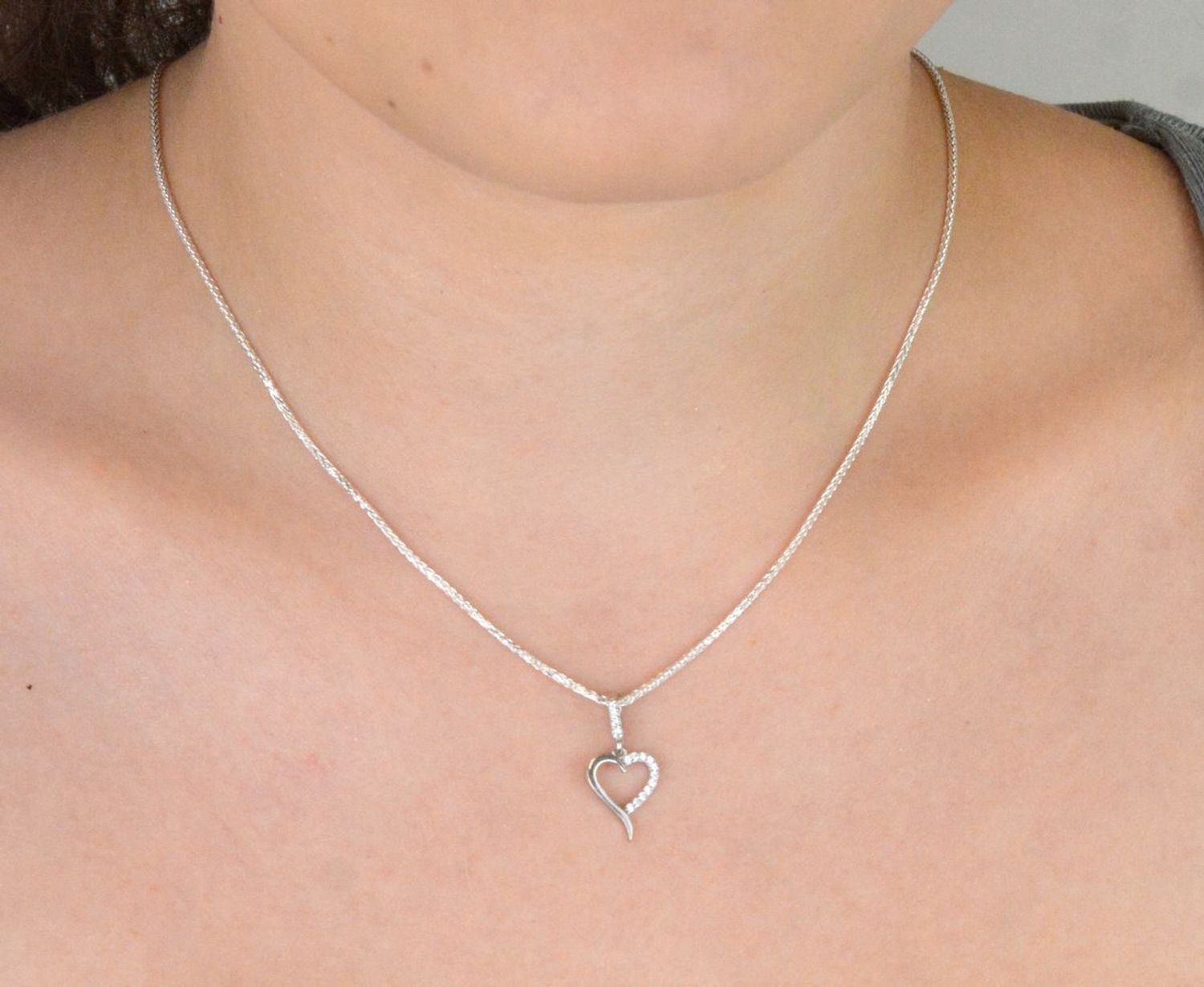 Subtelna srebrna zawieszka DIA-ZAW-13334-925 w kształcie małego, otwartego serca, zdobiona cyrkoniami. Próba 925, waga 0,70 g, długość 2,0 cm x 1,0 cm. Idealna na prezent z miłością.1.jpg