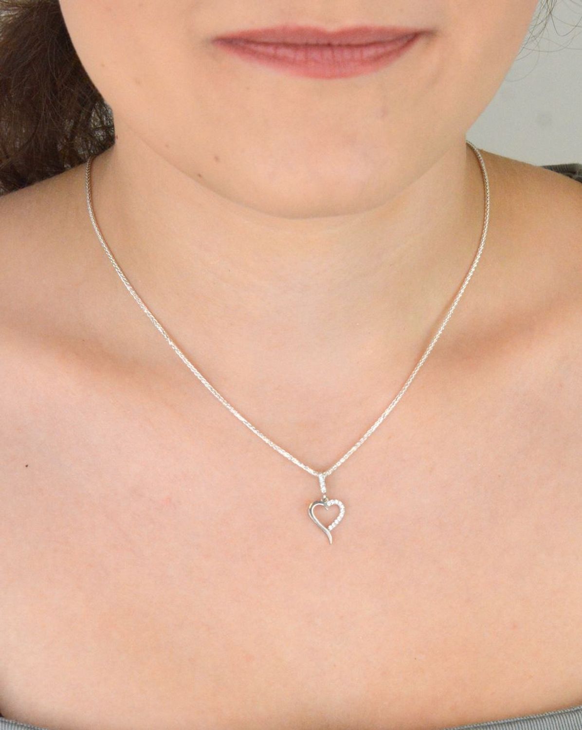 Subtelna srebrna zawieszka DIA-ZAW-13334-925 w kształcie małego, otwartego serca, zdobiona cyrkoniami. Próba 925, waga 0,70 g, długość 2,0 cm x 1,0 cm. Idealna na prezent z miłością.1.jpg