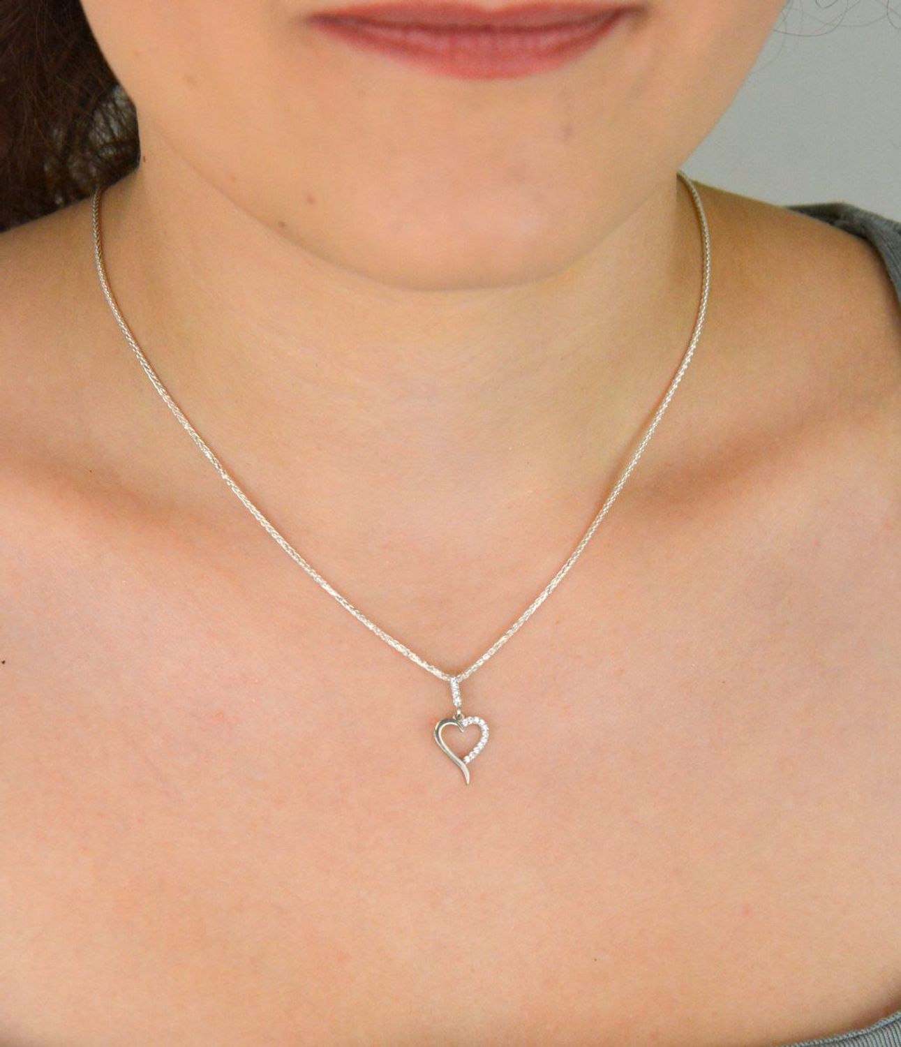 Subtelna srebrna zawieszka DIA-ZAW-13334-925 w kształcie małego, otwartego serca, zdobiona cyrkoniami. Próba 925, waga 0,70 g, długość 2,0 cm x 1,0 cm. Idealna na prezent z miłością.1.jpg