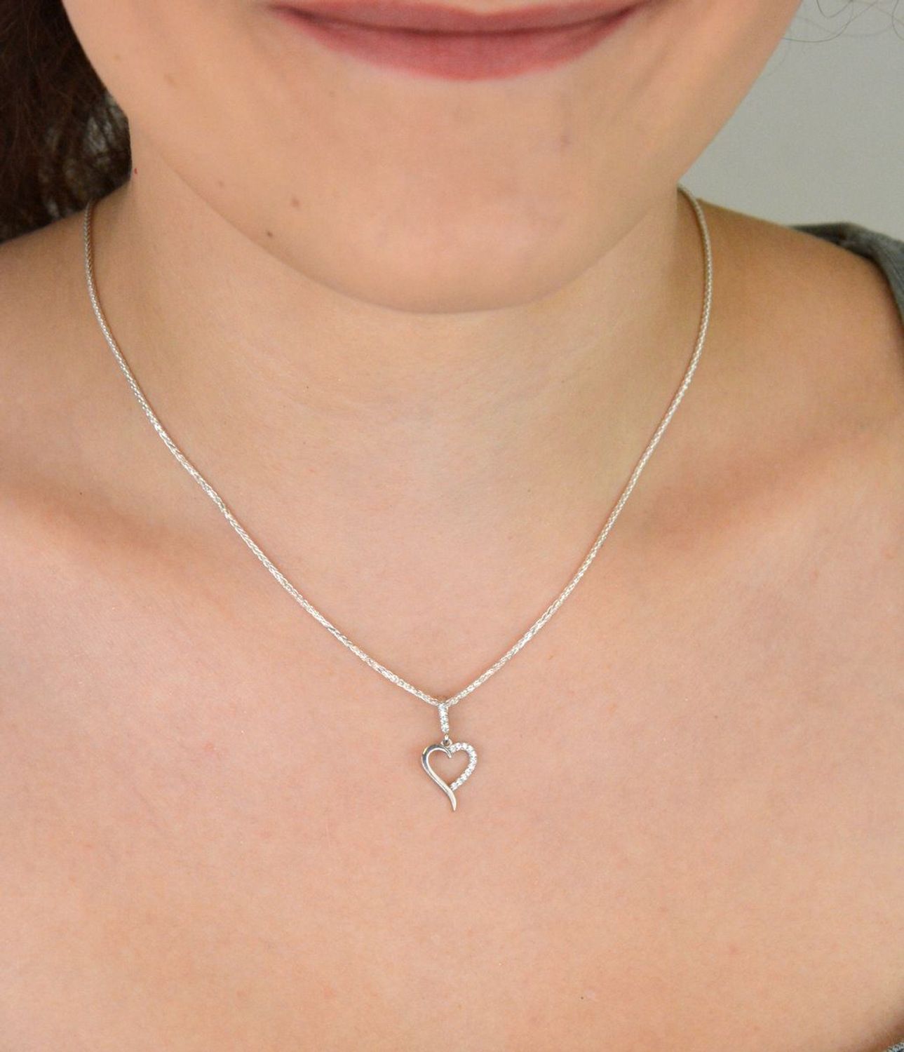 Subtelna srebrna zawieszka DIA-ZAW-13334-925 w kształcie małego, otwartego serca, zdobiona cyrkoniami. Próba 925, waga 0,70 g, długość 2,0 cm x 1,0 cm. Idealna na prezent z miłością.1.jpg