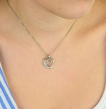 Zawieszka srebrna DIA-ZAW-13335-925 w kształcie dwóch serc, jedno ozdobione delikatną cyrkonią. Srebro próby 925, długość 2,0 cm, szerokość 1,5 cm, waga 1,80 g. Symboliczna i kobieca (1).JPG