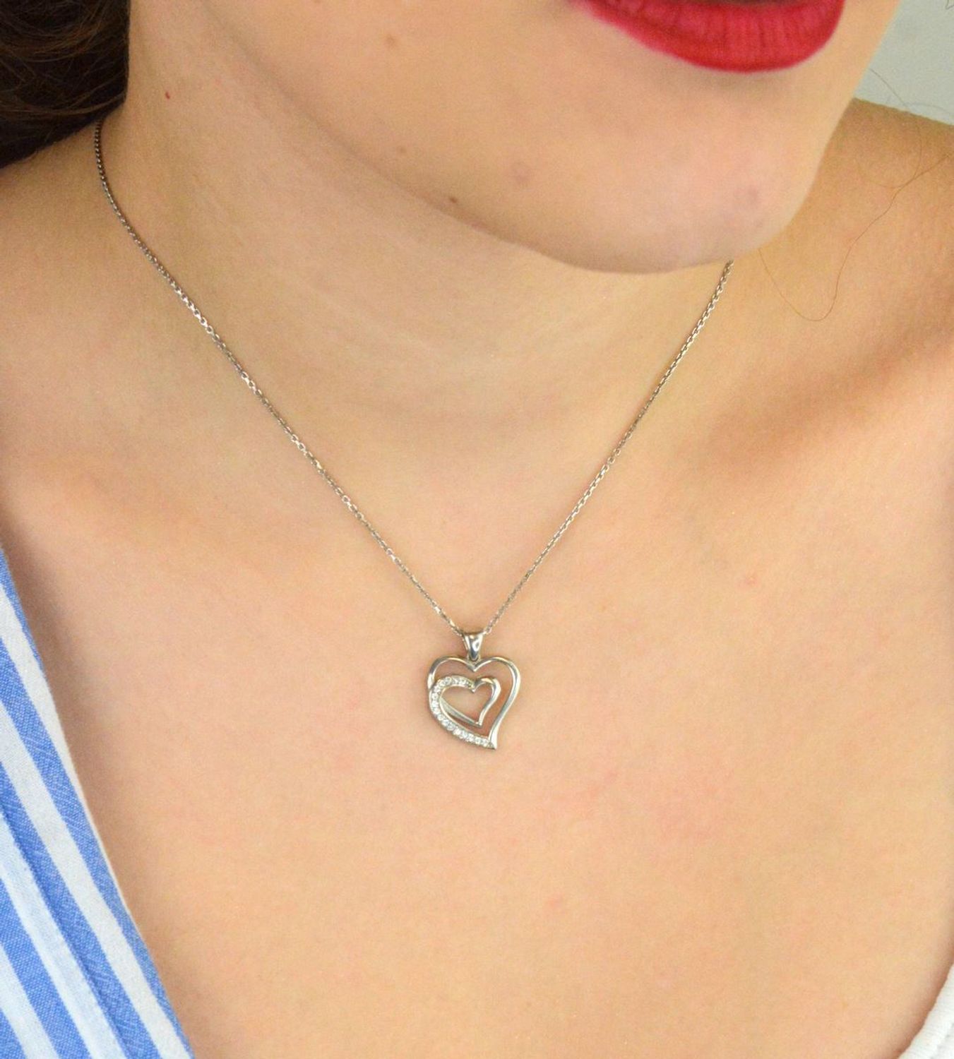 Zawieszka srebrna DIA-ZAW-13335-925 w kształcie dwóch serc, jedno ozdobione delikatną cyrkonią. Srebro próby 925, długość 2,0 cm, szerokość 1,5 cm, waga 1,80 g. Symboliczna i kobieca.1.jpg