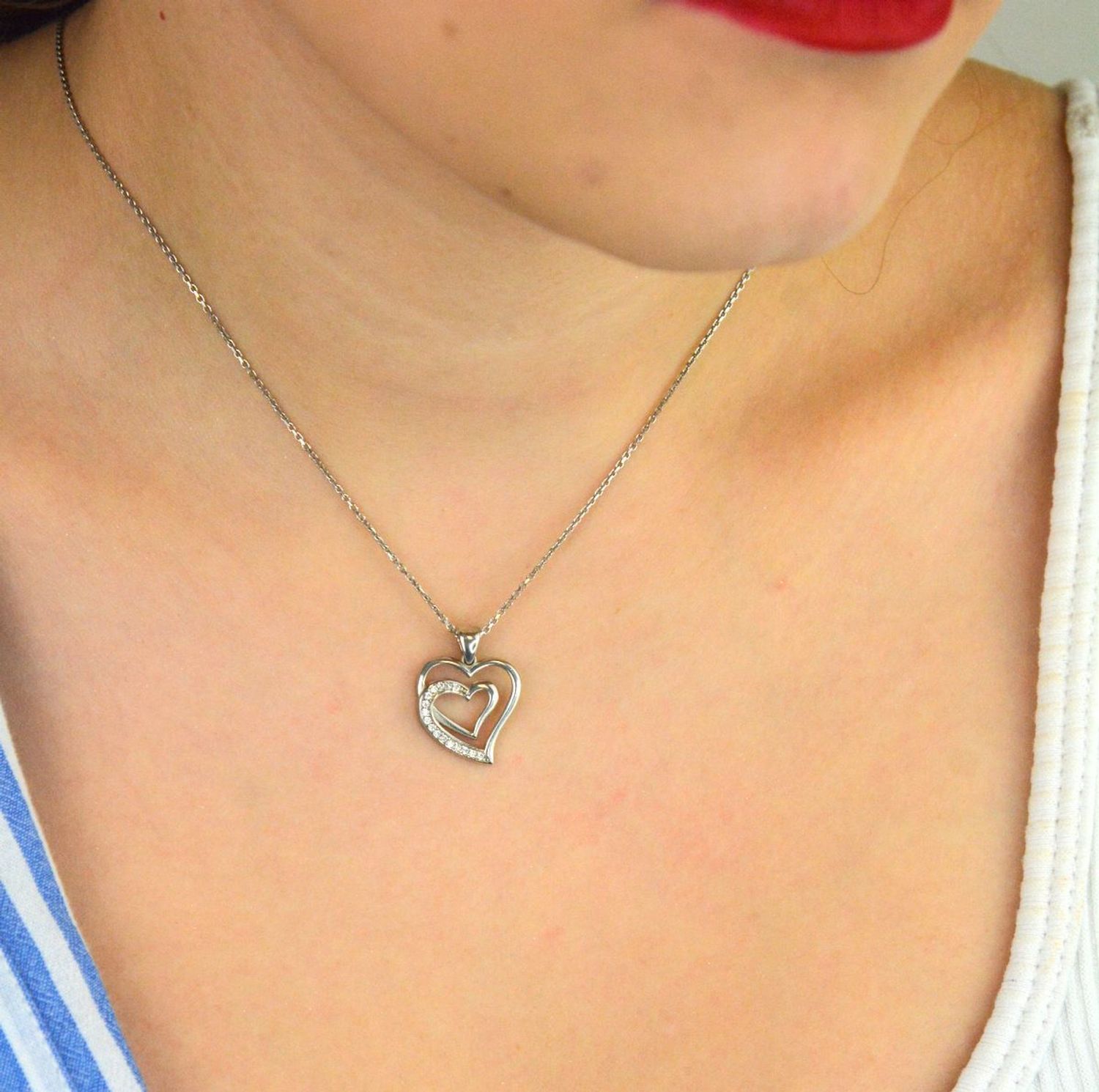 Zawieszka srebrna DIA-ZAW-13335-925 w kształcie dwóch serc, jedno ozdobione delikatną cyrkonią. Srebro próby 925, długość 2,0 cm, szerokość 1,5 cm, waga 1,80 g. Symboliczna i kobieca.1.jpg