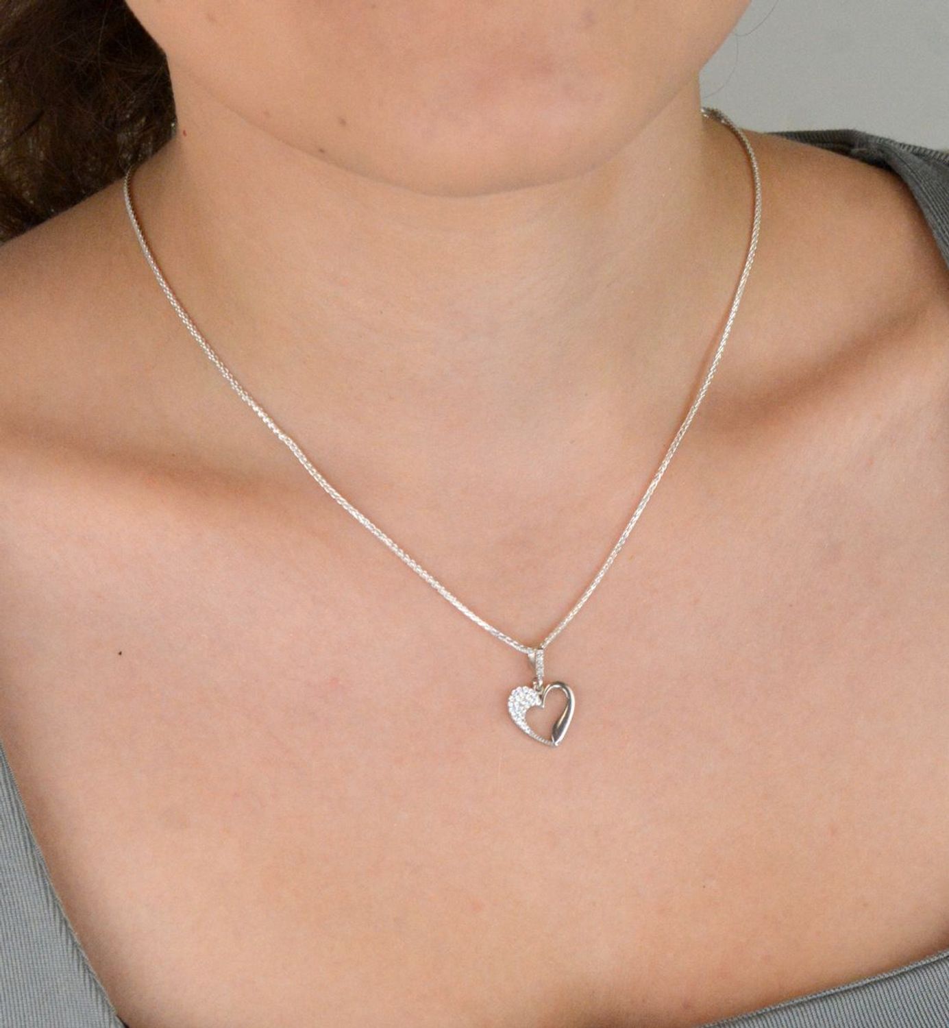 Elegancka srebrna zawieszka w kształcie serca, wykonana z najwyższej próby 925 i ozdobiona lśniącymi cyrkoniami. Waga 0,90 g, wymiary 1,3 x 2,0 cm. Idealna na prezent dla ukochanej.1.jpg