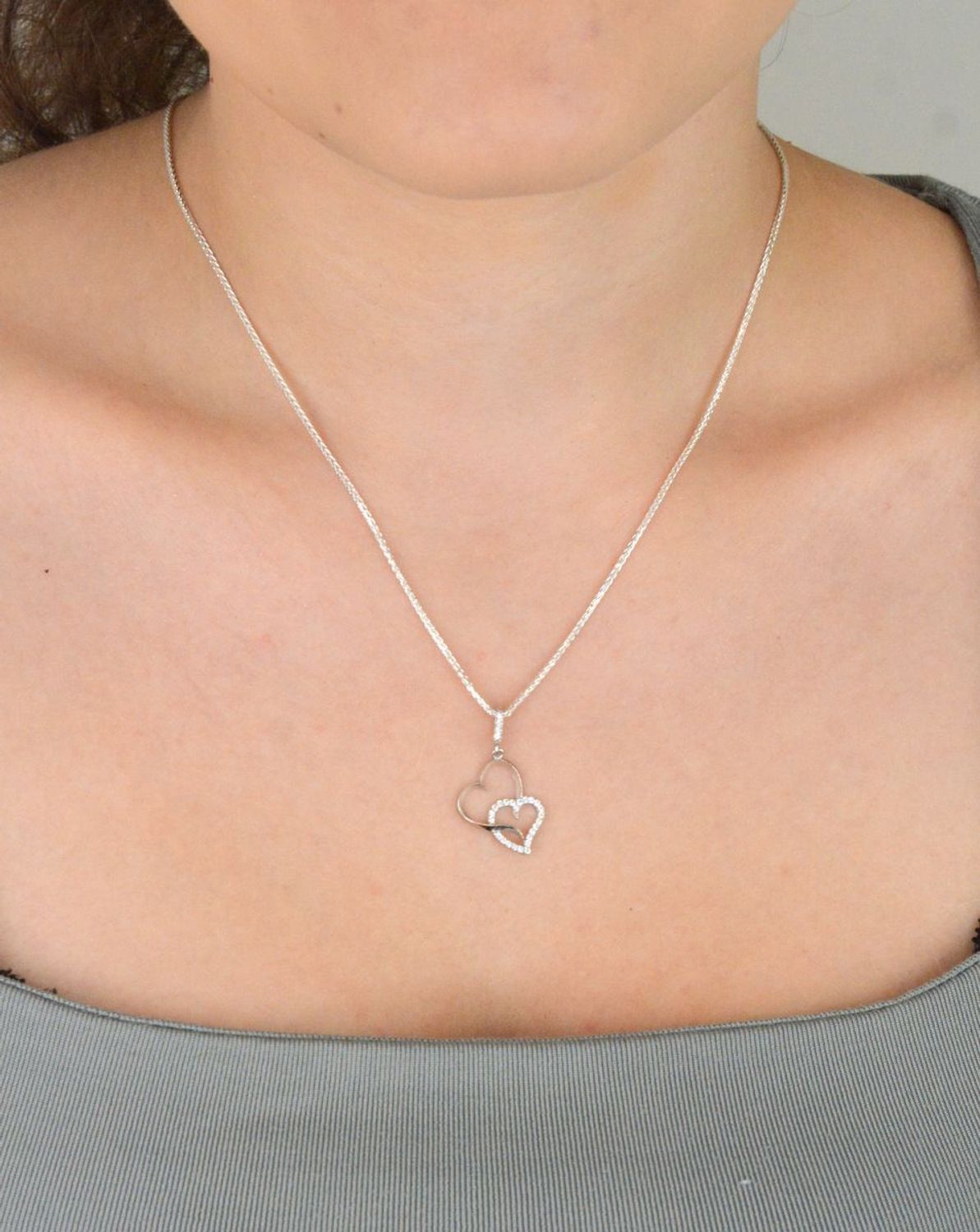 Romantyczna zawieszka srebrna DIA-ZAW-13337-925 z dwoma splecionymi sercami, jedno zdobione cyrkoniami. Srebro próby 925, długość 2,8 cm, szerokość 1,3 cm, waga 0,90 g.1.jpg