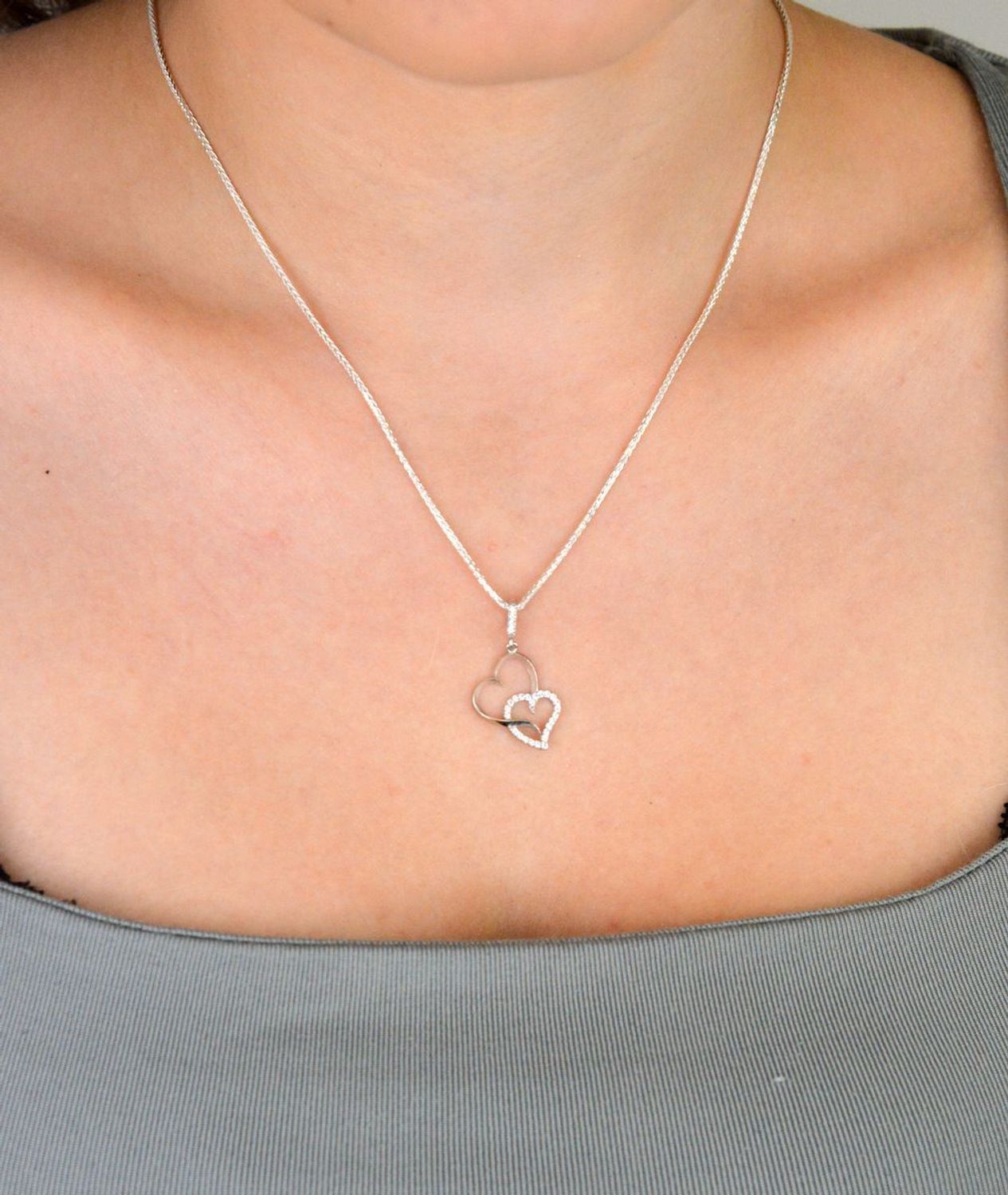 Romantyczna zawieszka srebrna DIA-ZAW-13337-925 z dwoma splecionymi sercami, jedno zdobione cyrkoniami. Srebro próby 925, długość 2,8 cm, szerokość 1,3 cm, waga 0,90 g.1.jpg