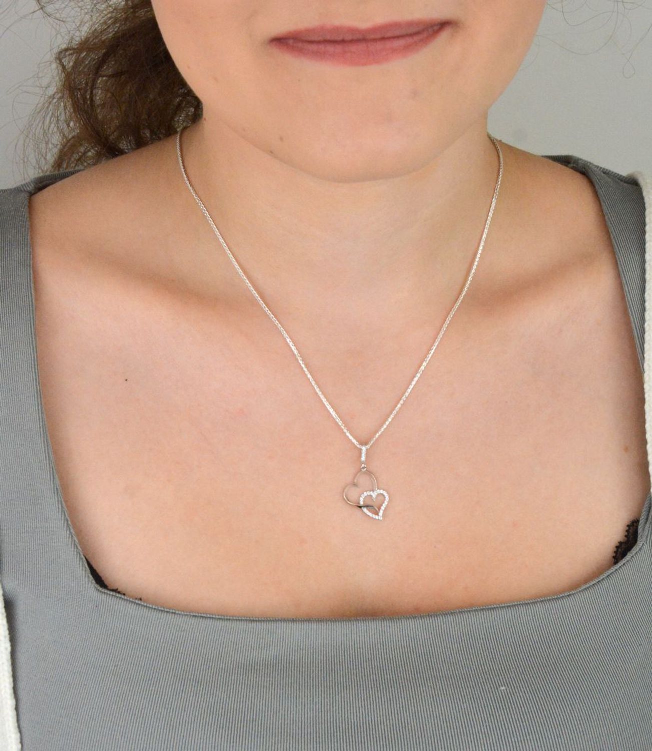 Romantyczna zawieszka srebrna DIA-ZAW-13337-925 z dwoma splecionymi sercami, jedno zdobione cyrkoniami. Srebro próby 925, długość 2,8 cm, szerokość 1,3 cm, waga 0,90 g.1.jpg