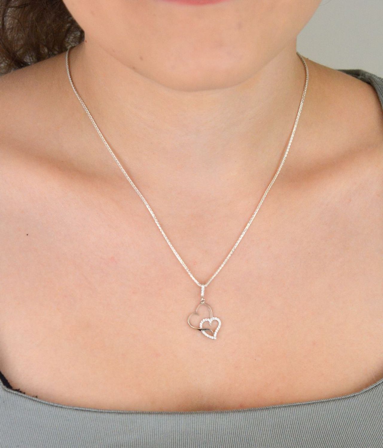 Romantyczna zawieszka srebrna DIA-ZAW-13337-925 z dwoma splecionymi sercami, jedno zdobione cyrkoniami. Srebro próby 925, długość 2,8 cm, szerokość 1,3 cm, waga 0,90 g.1.jpg