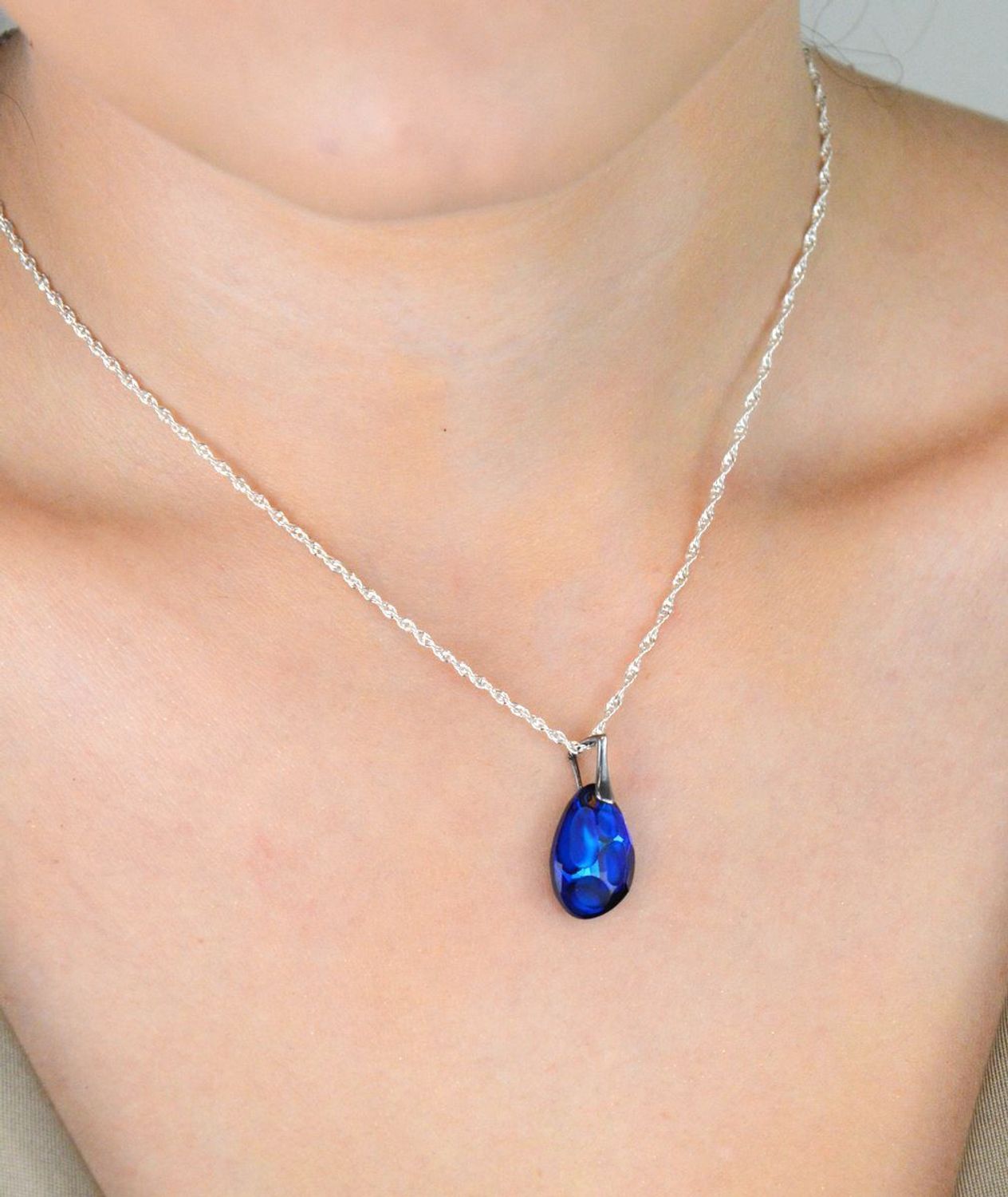 Owalna zawieszka damska ze srebra 925 z granatowym kamieniem syntetycznym. Elegancka biżuteria o wymiarach 2,5 x 1,1 cm i wadze 1,40 g. Model DIA-ZAW-13493-925 – wyraz klasy i koloru.1.jpg